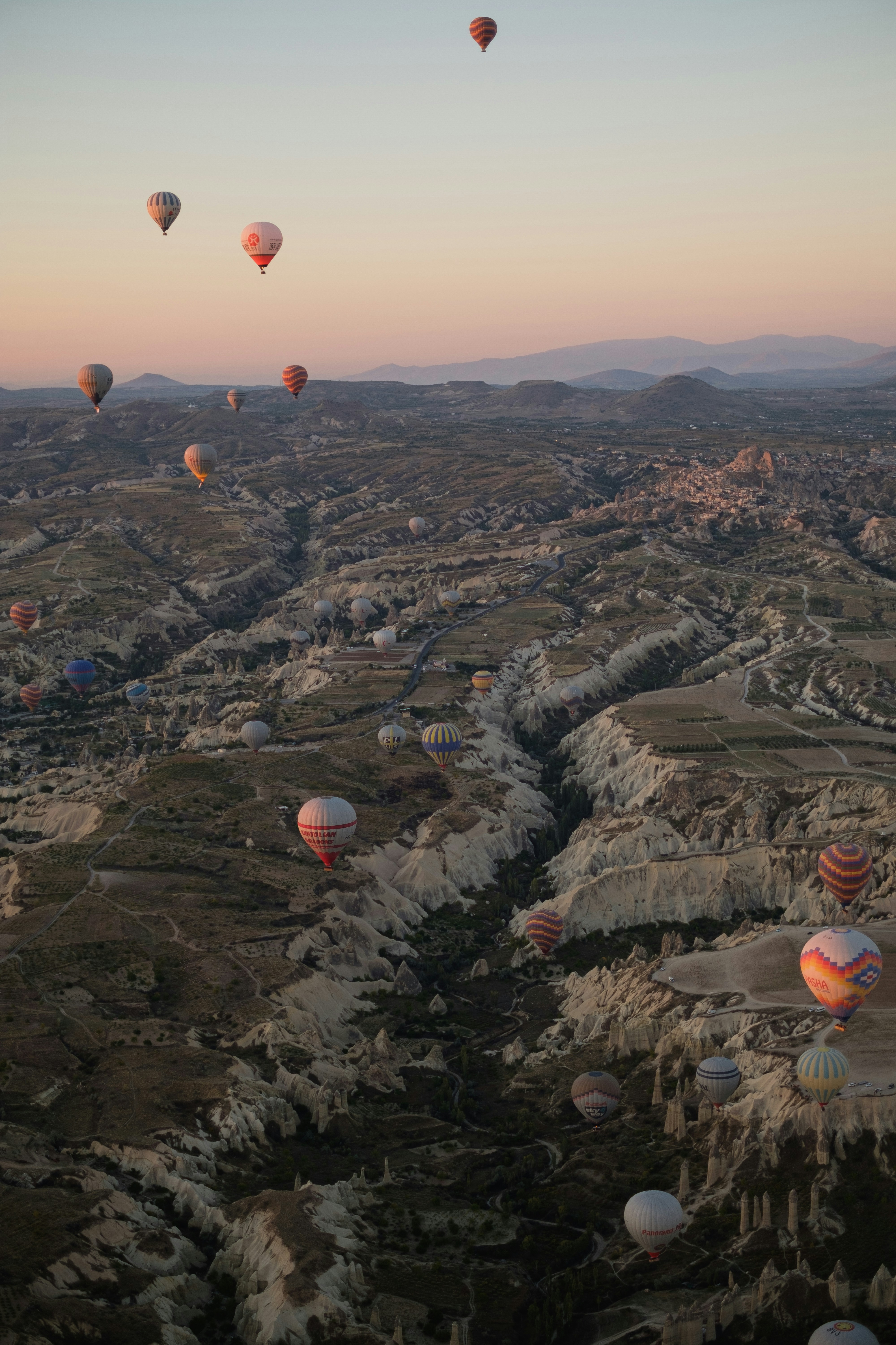 A group of hot air balloons flying over a valley