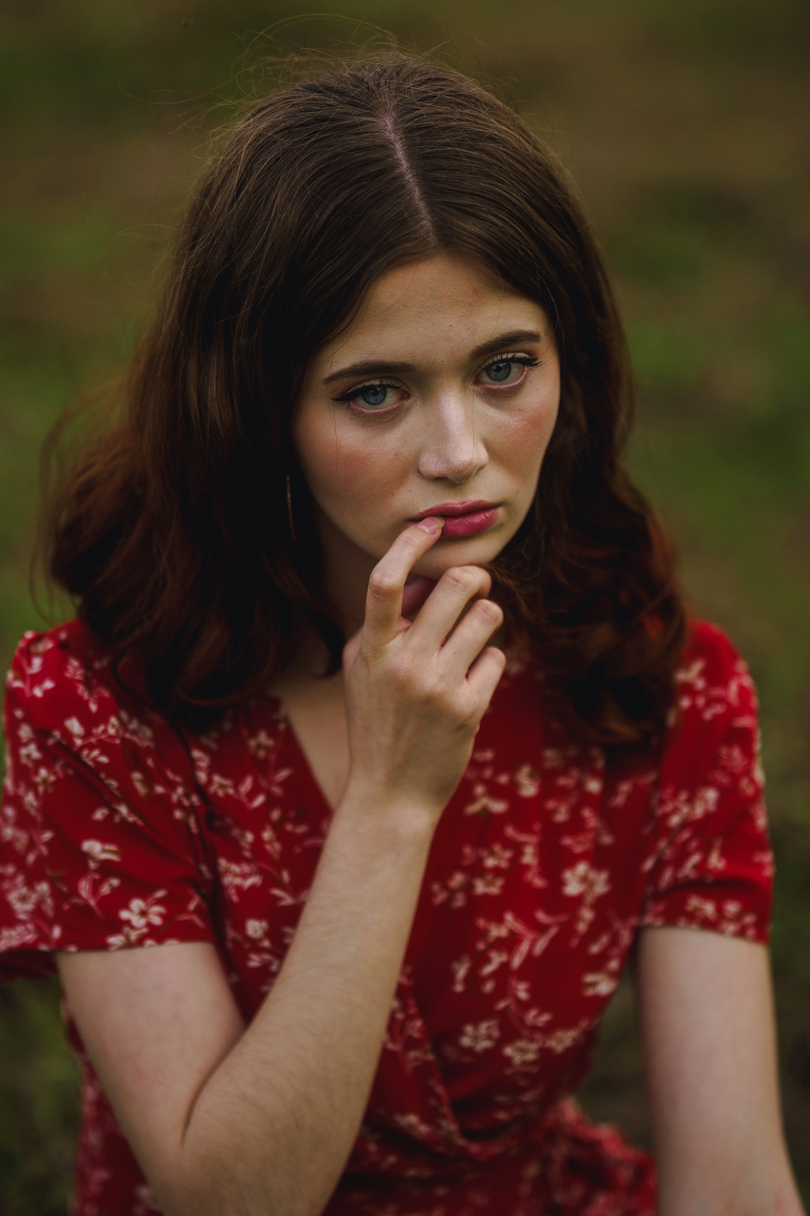 A woman in a red dress holding her hand to her mouth