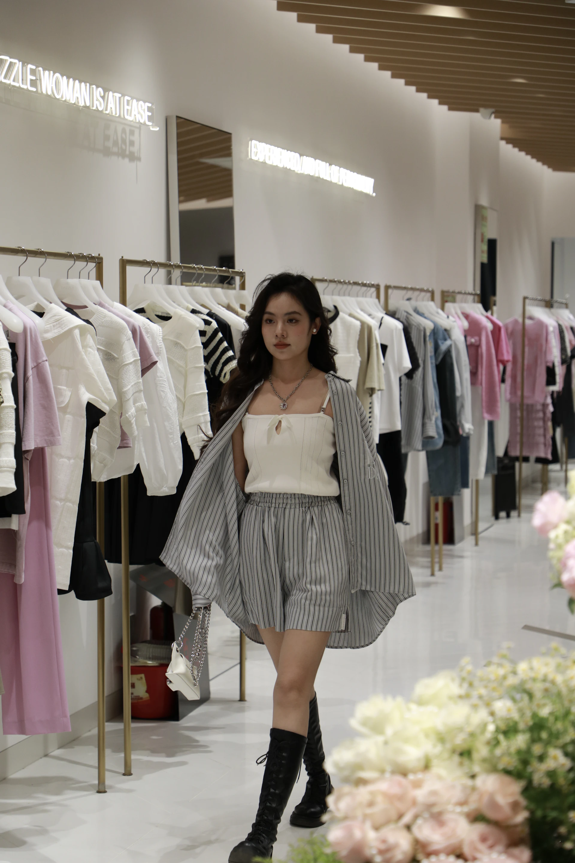 A woman is walking through a clothing store
