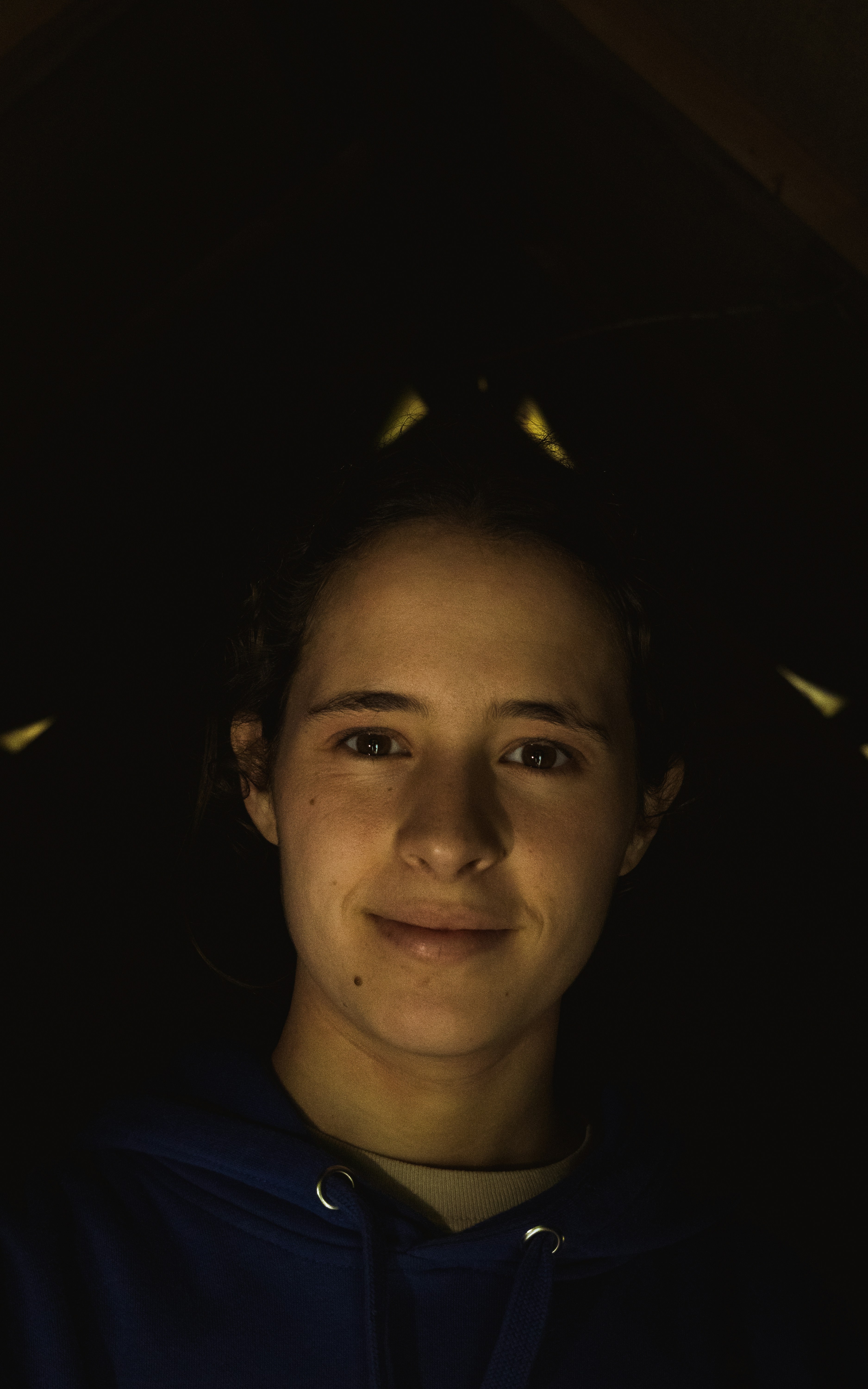 Young woman with bright smile in a casual setting, warm natural lighting