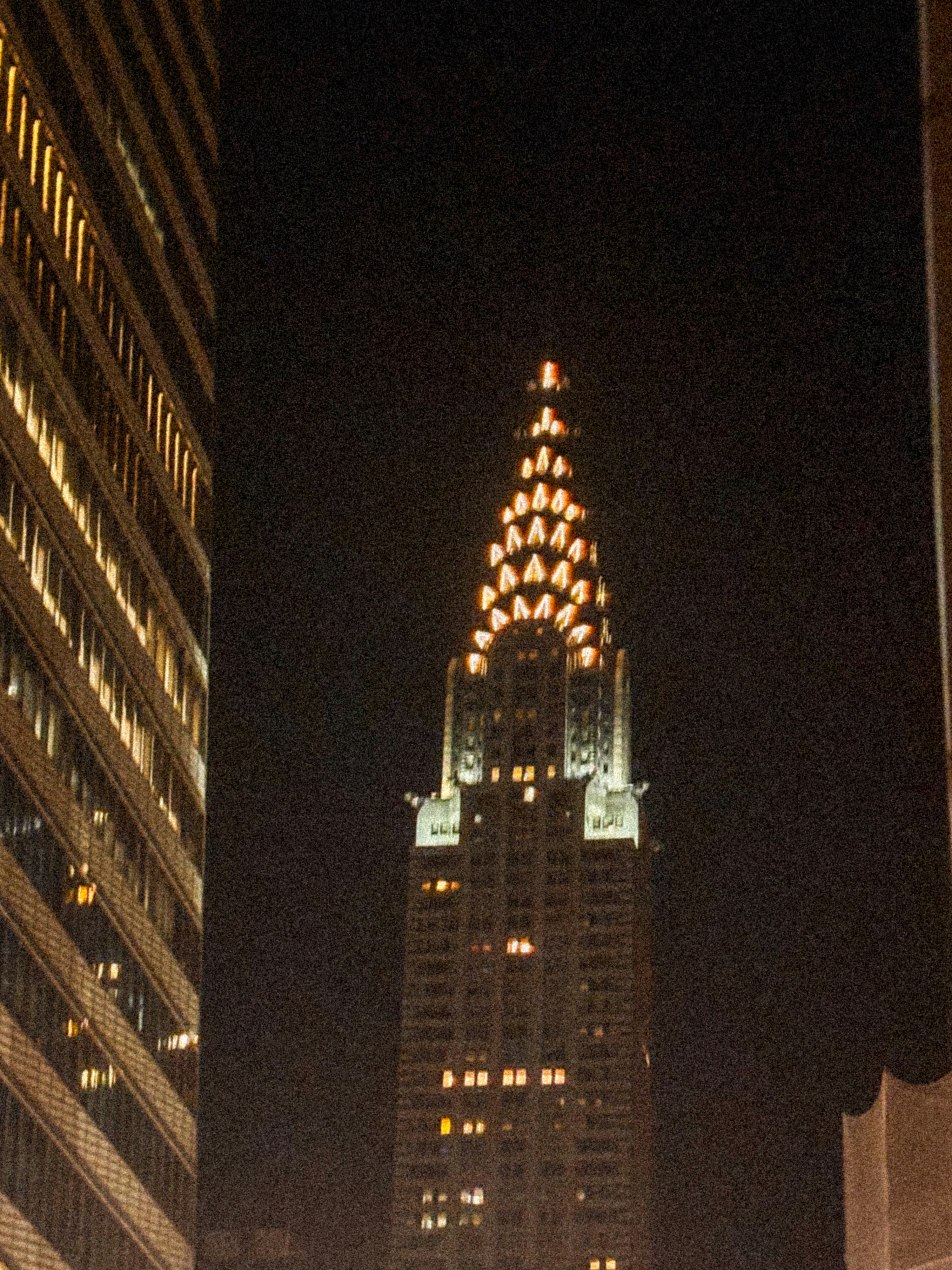 Ein hohes, nachts beleuchtetes Gebäude in einer Stadt