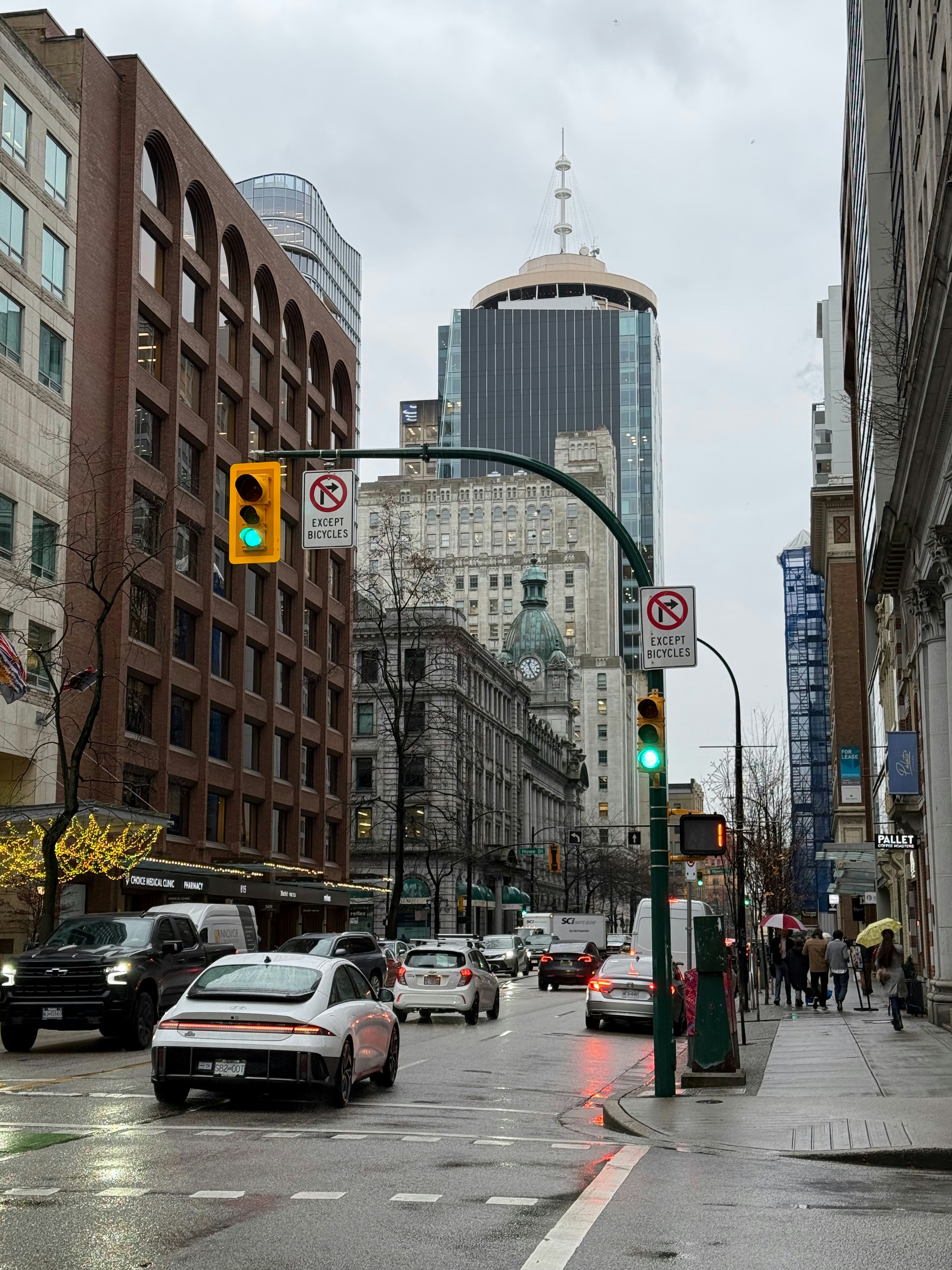 A city street filled with traffic next to tall buildings