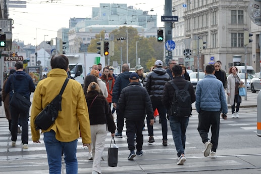 A group of people walking across a street