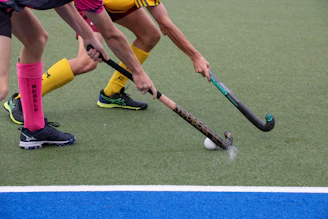A group of people playing a game of field hockey