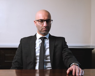 A man in a suit and tie sitting at a table