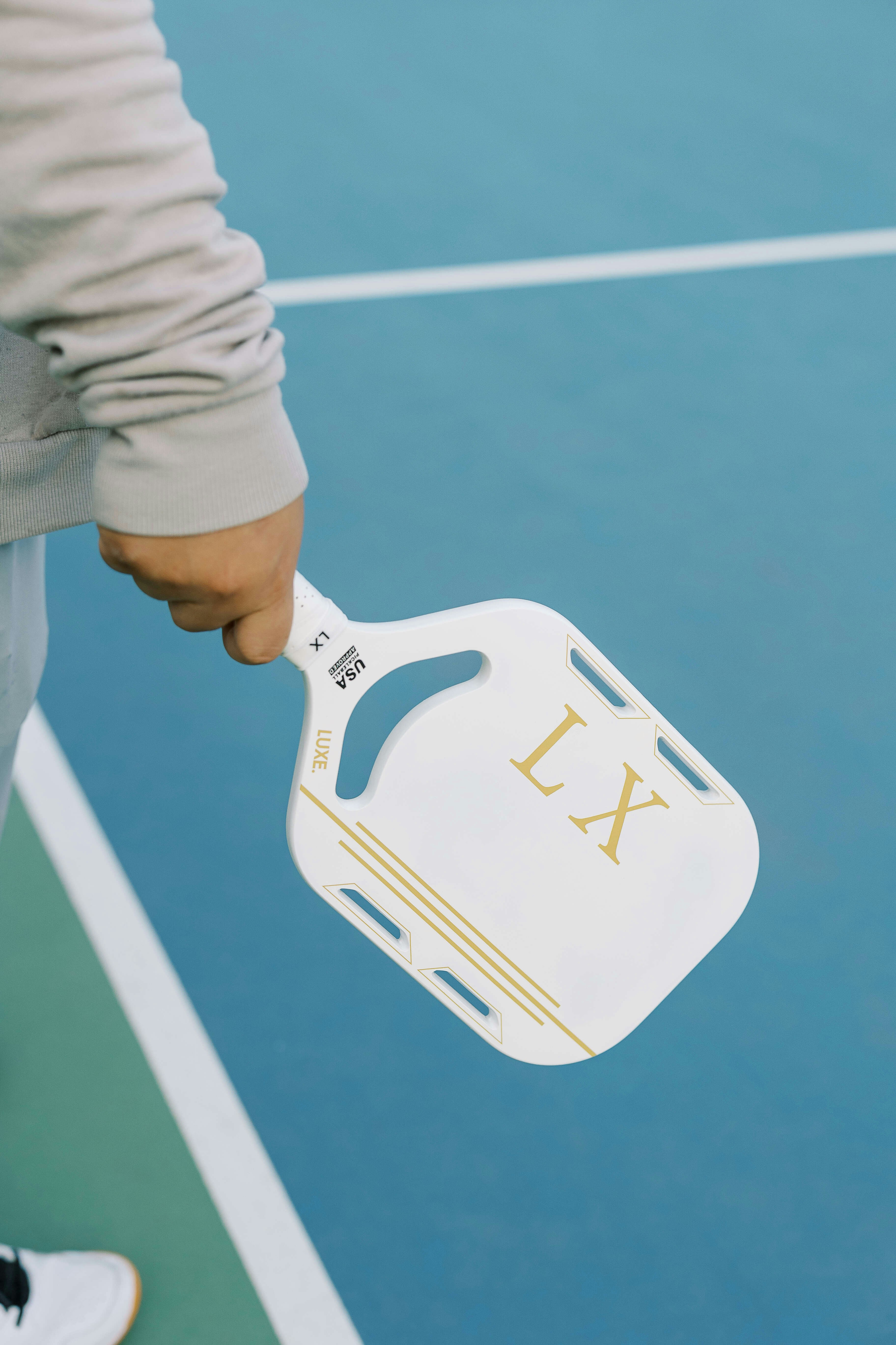 A person holding a tennis racquet on a tennis court