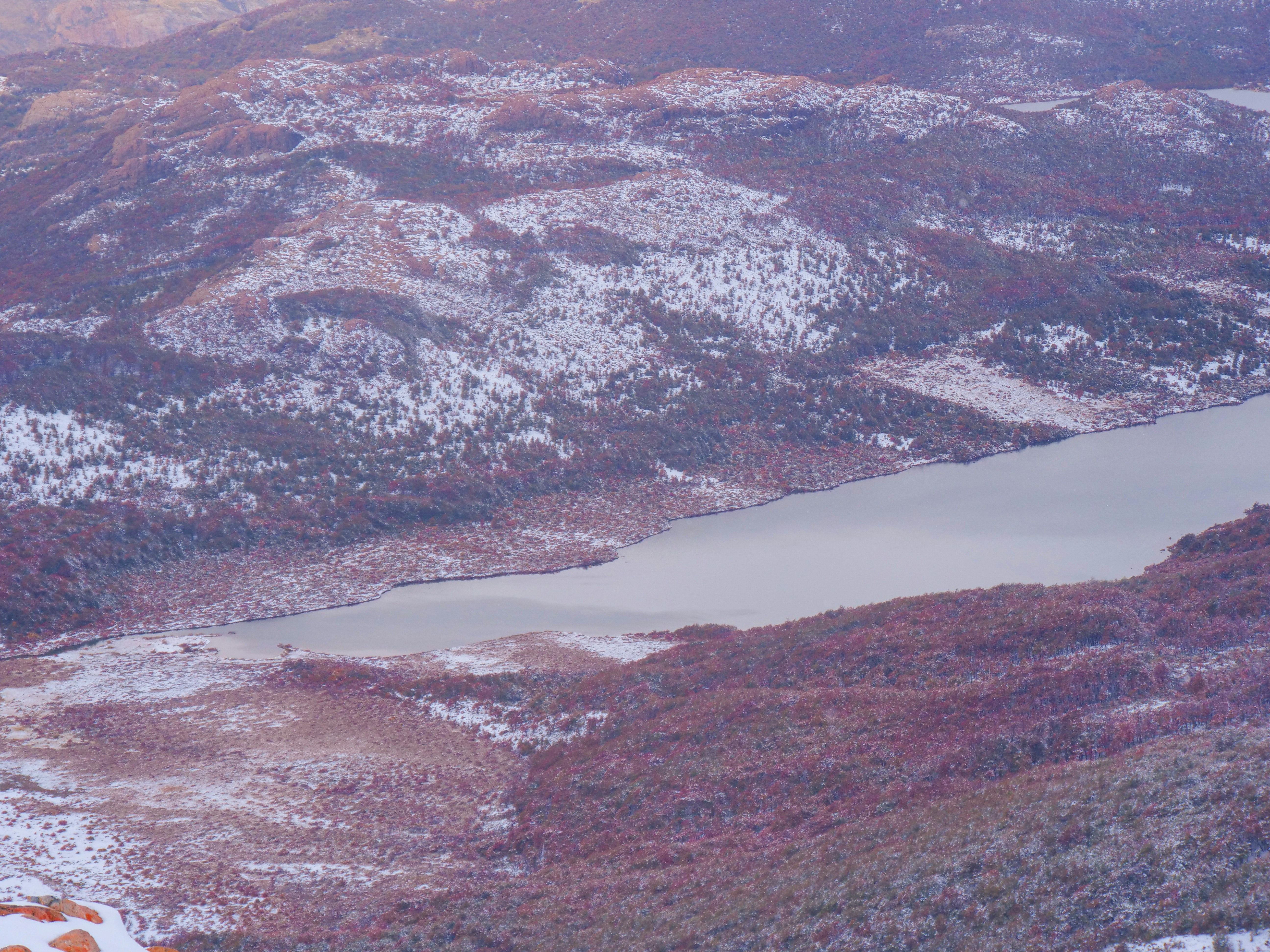A snow covered mountain with a lake in the middle