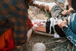 A group of men standing around a man laying on the ground