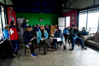 A group of people sitting around each other in a room