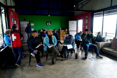 A group of people sitting around each other in a room
