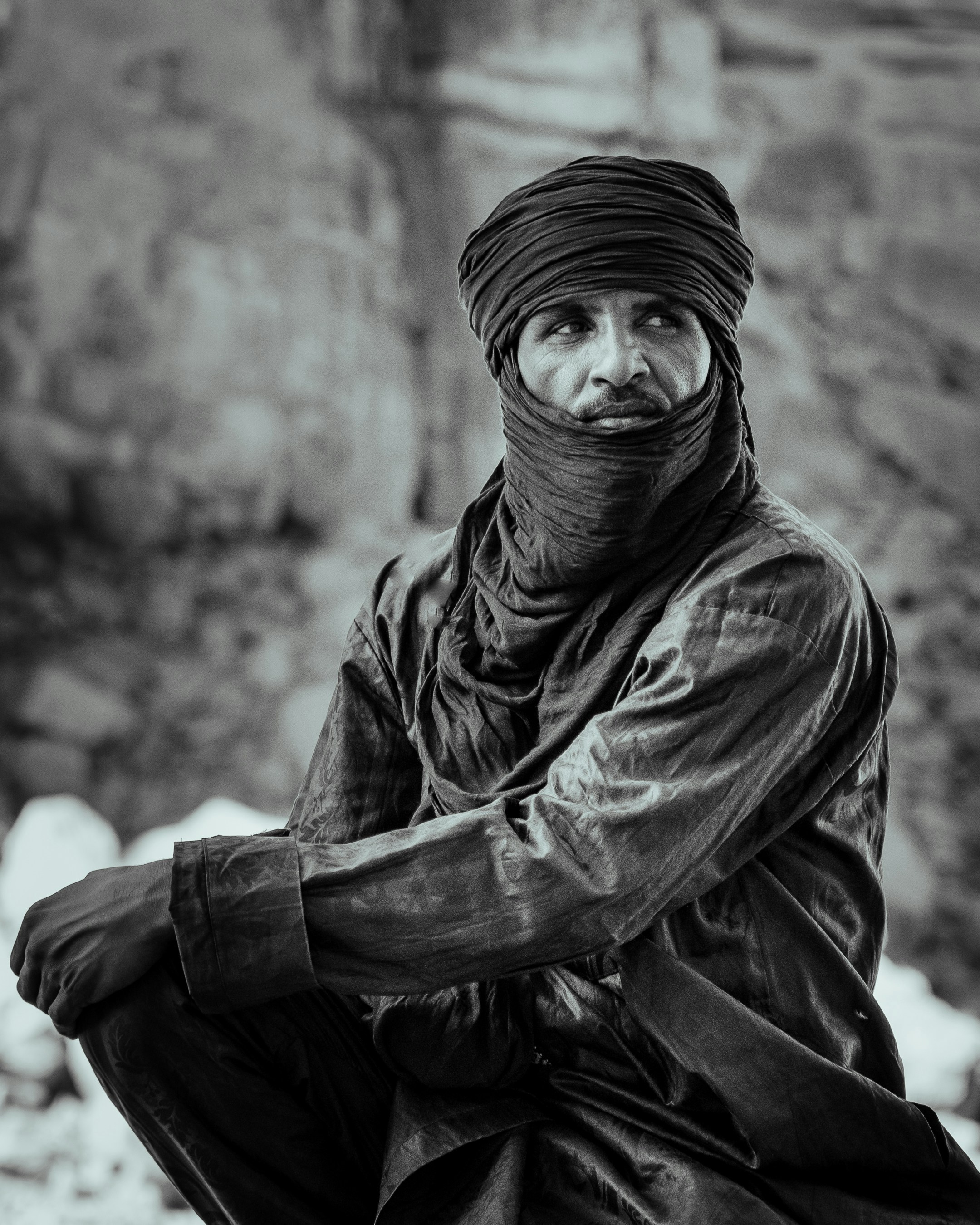 A man in a turban sitting on a rock
