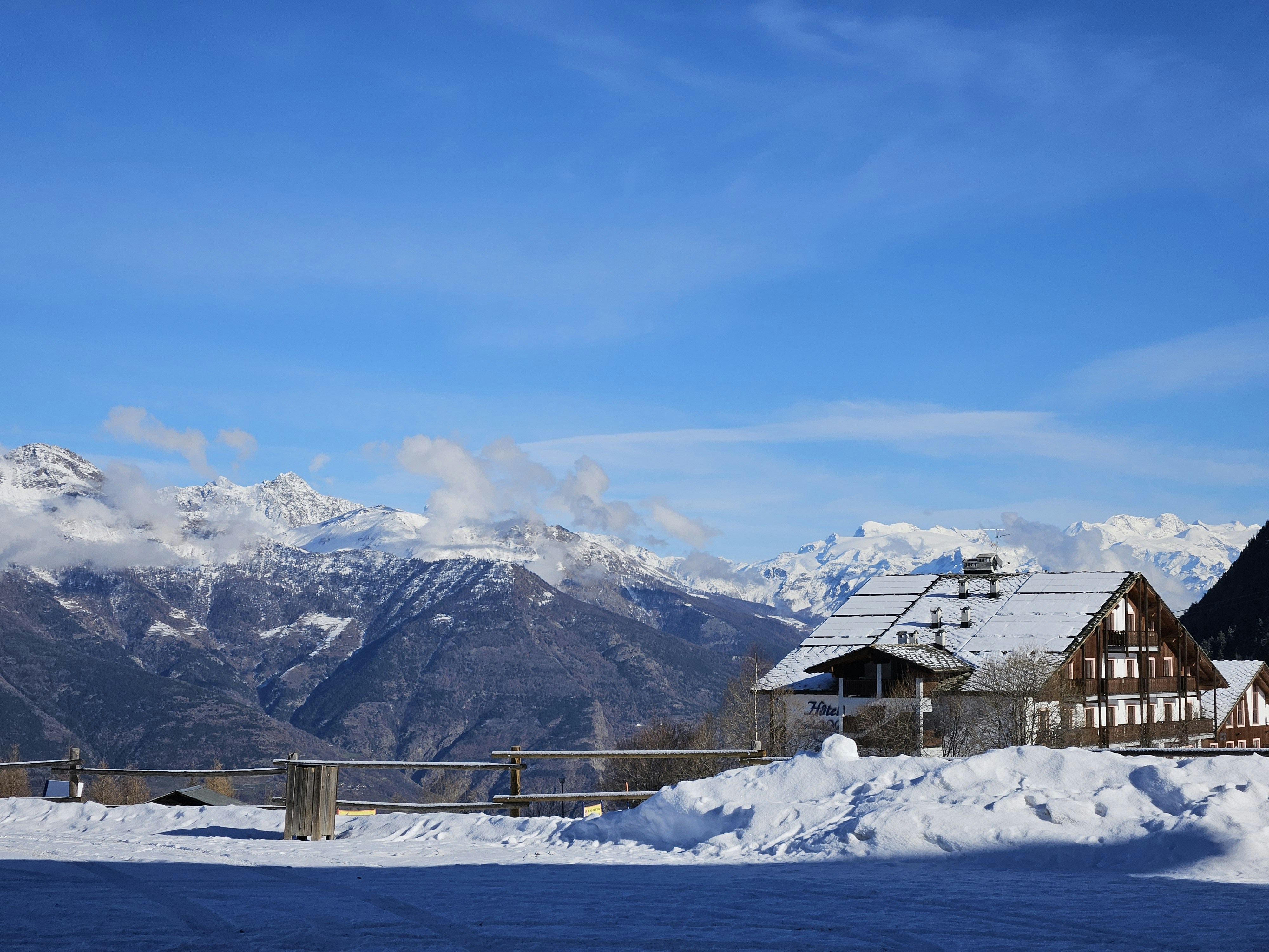 A house in the snow with mountains in the background