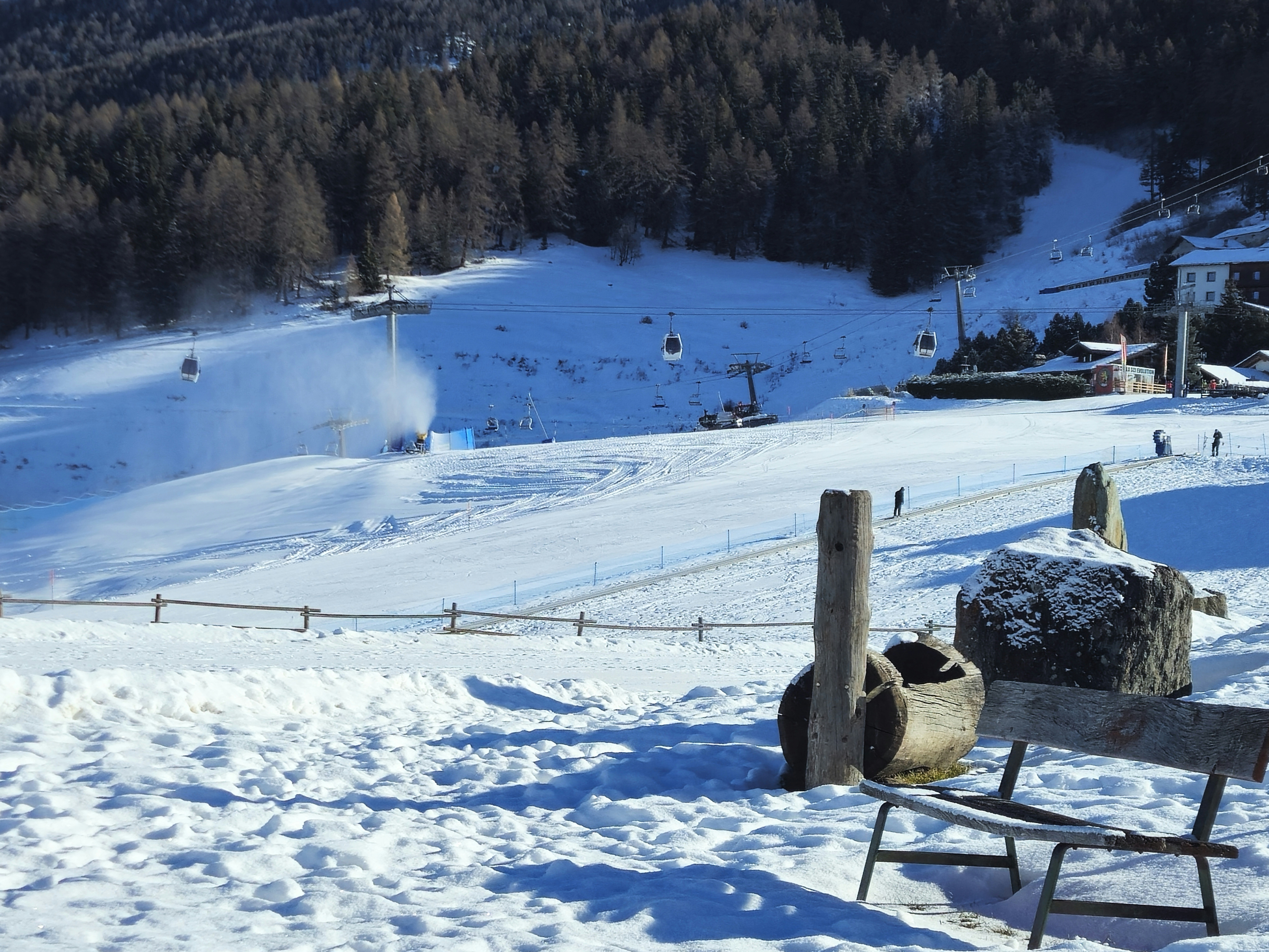 A bench sitting on top of a snow covered slope