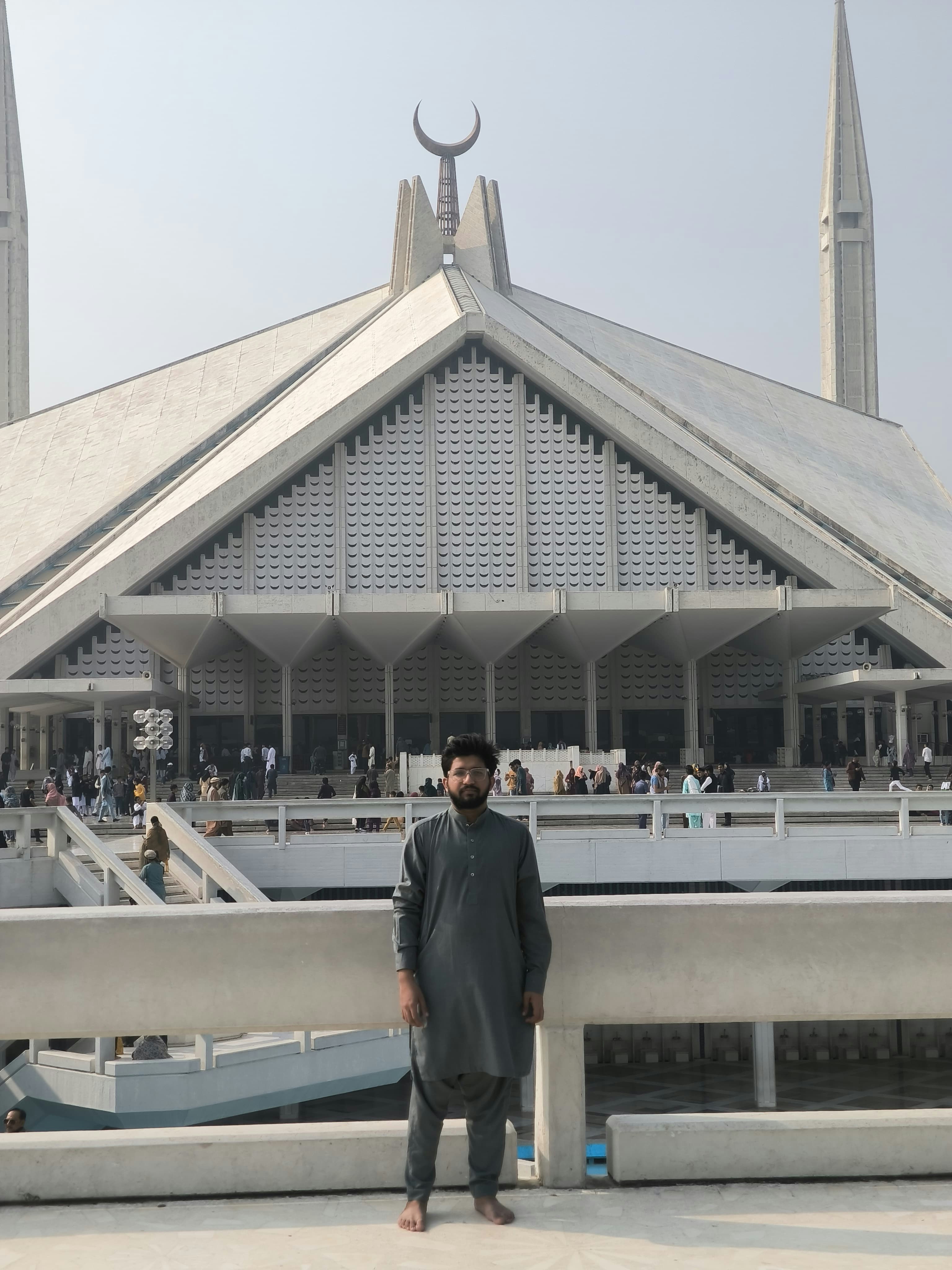 Un hombre de pie frente a un gran edificio