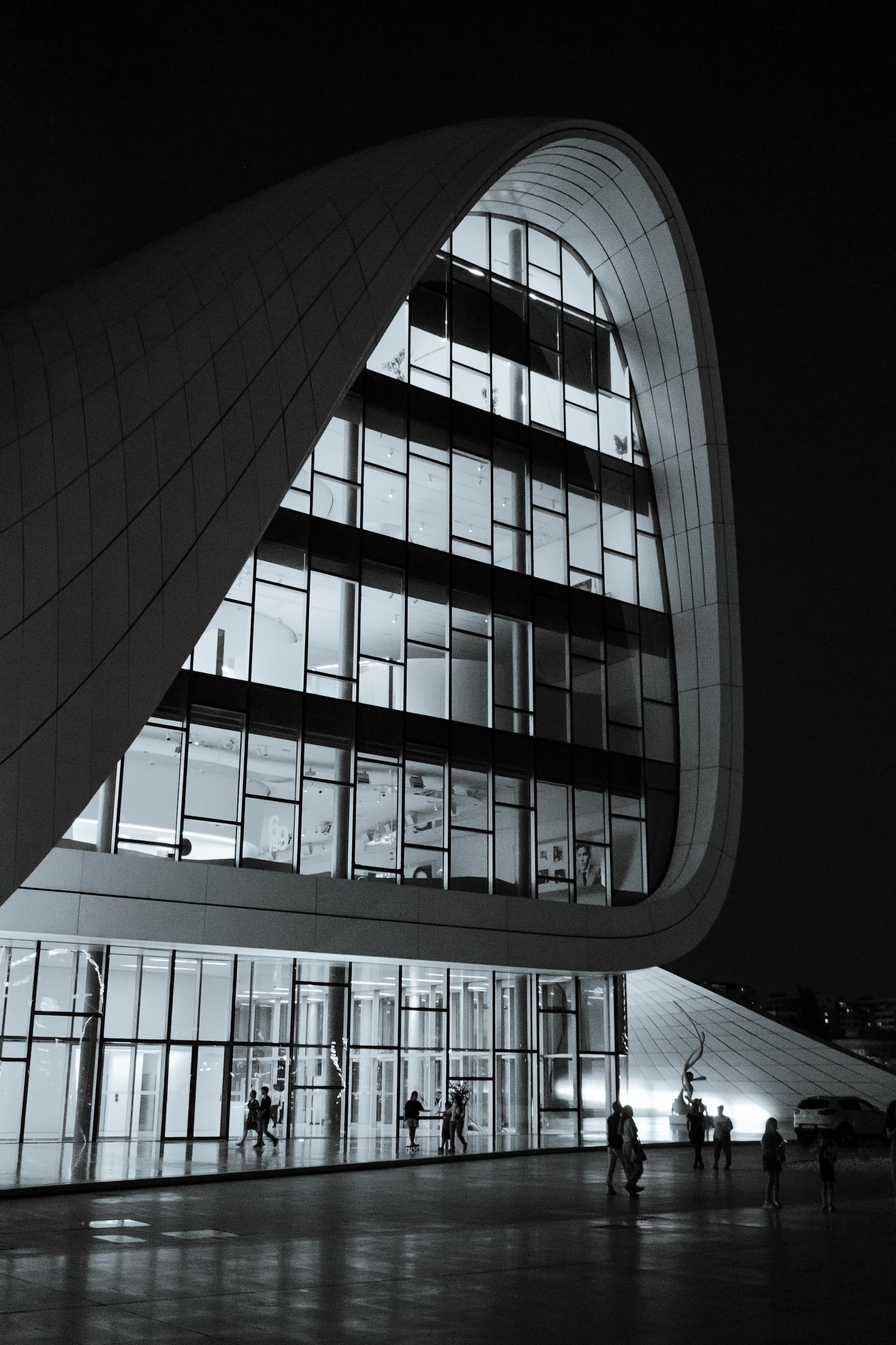 A large building with a curved roof at night