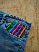 A pair of jeans with colored pencils sticking out of it