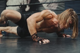 A man doing a handstand on a wrestling ring