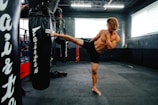 A man doing a kickbox kick in a gym