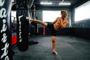 A man doing a kickbox kick in a gym