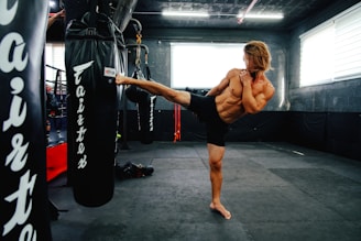 A man doing a kickbox kick in a gym