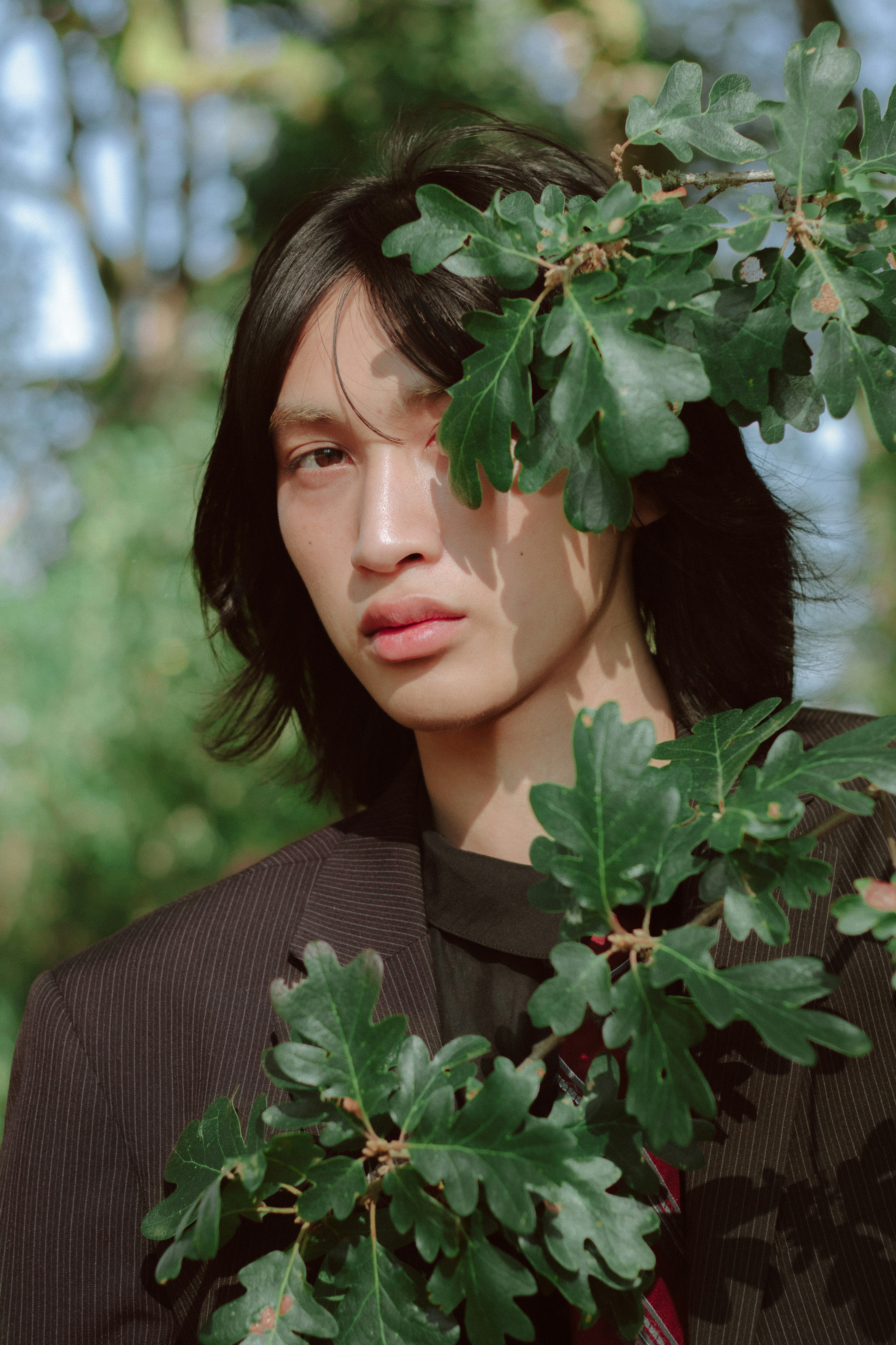 Um homem de terno e gravata em frente a uma árvore