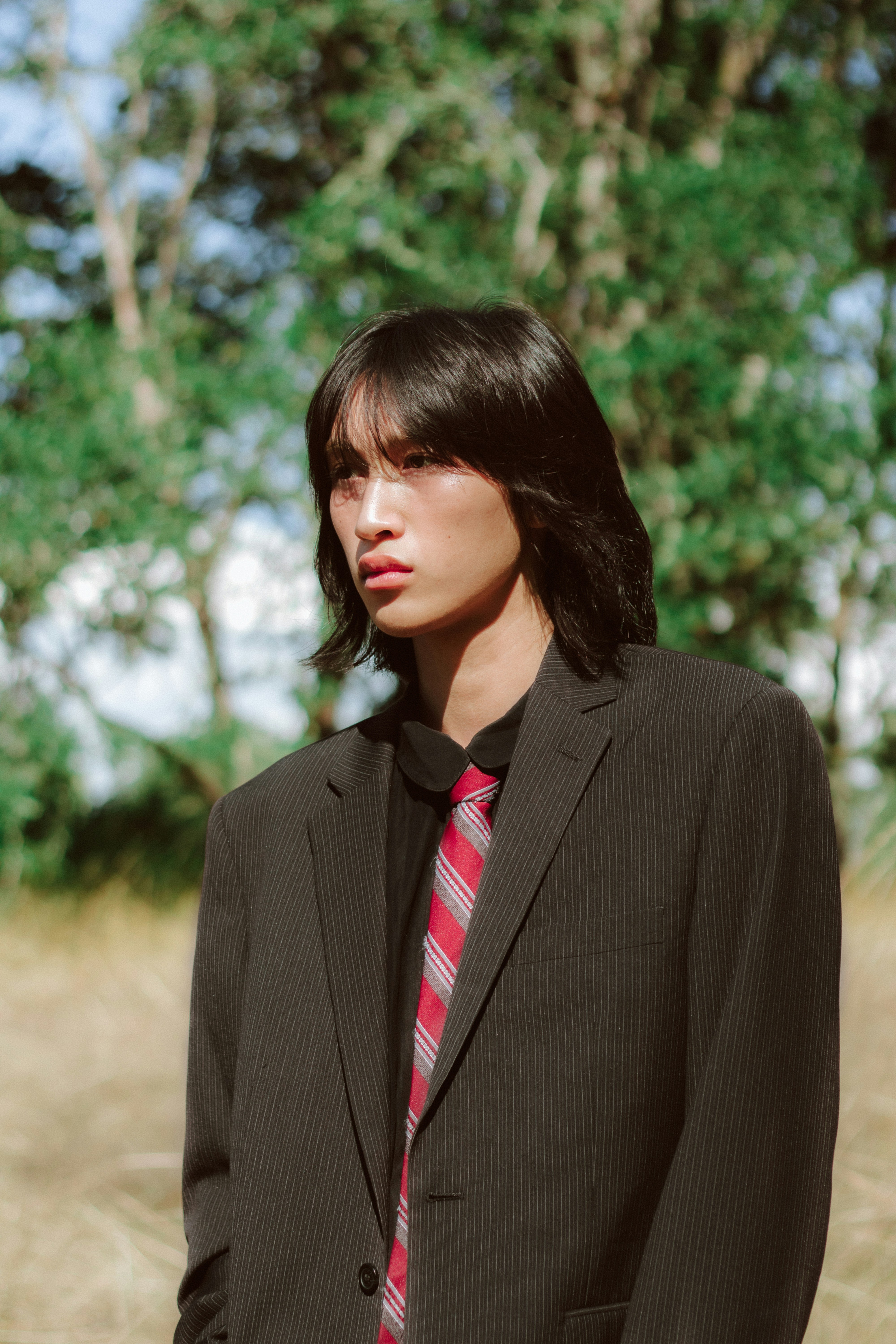 Uma mulher de terno e gravata em pé em um campo
