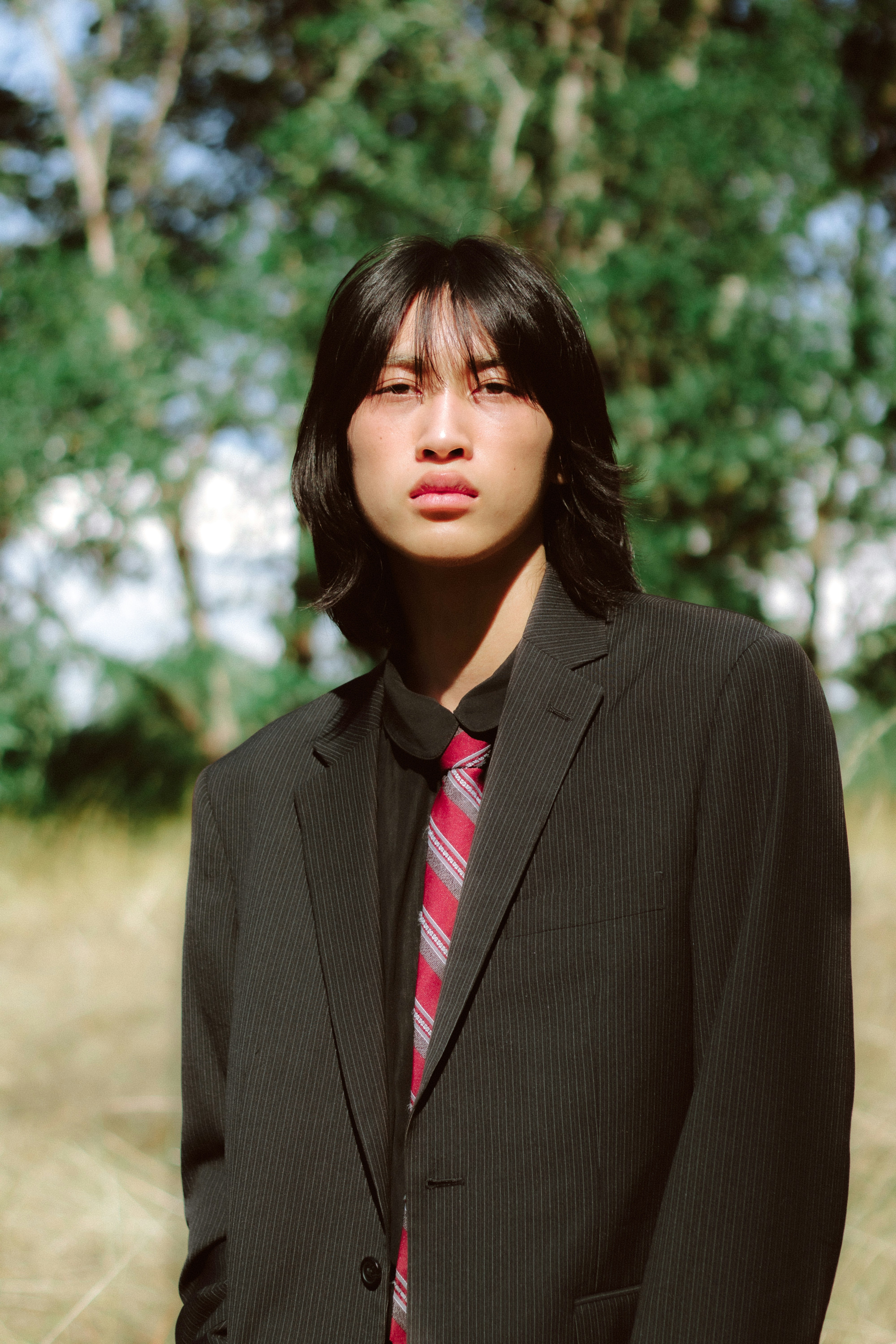 Um homem de terno e gravata em pé em um campo