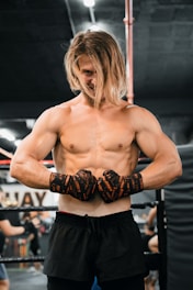 A shirtless man standing in a boxing ring