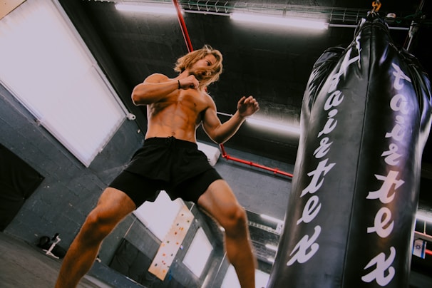 A man standing next to a punching bag