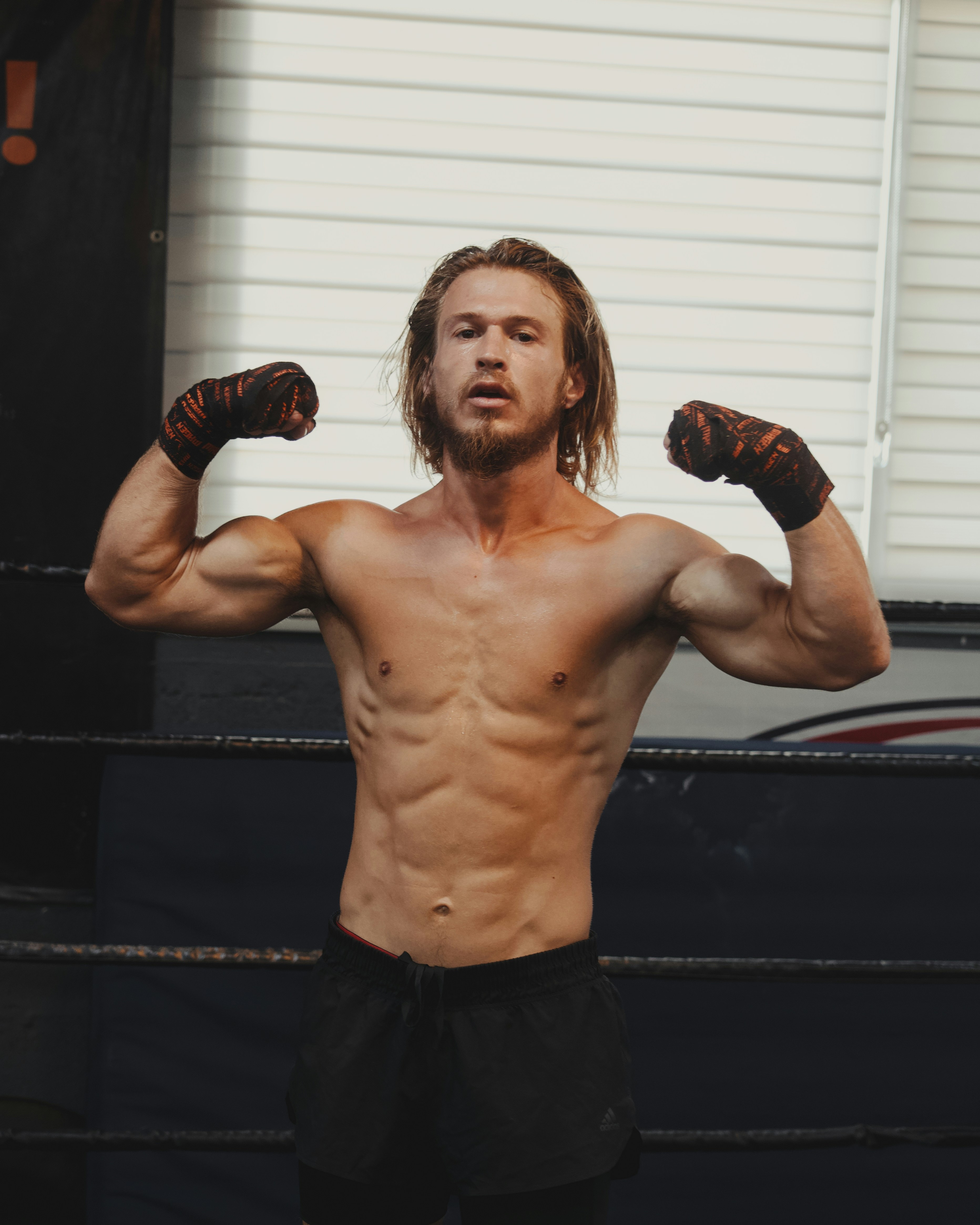 A shirtless man standing in a boxing ring