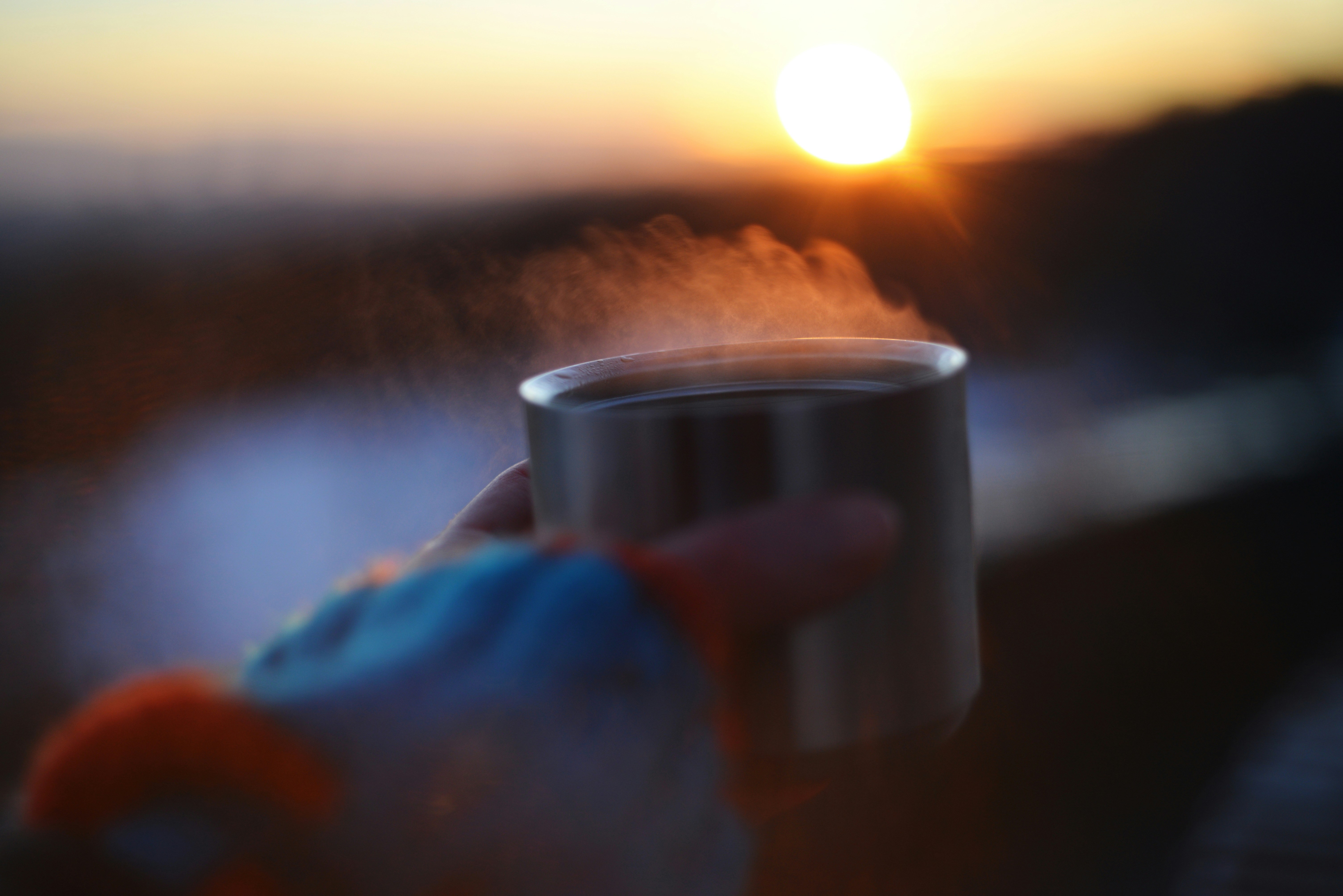 A person enjoying a cup of coffee on a balcony overlooking Lake Michigan at sunrise. - high rise apartments near me