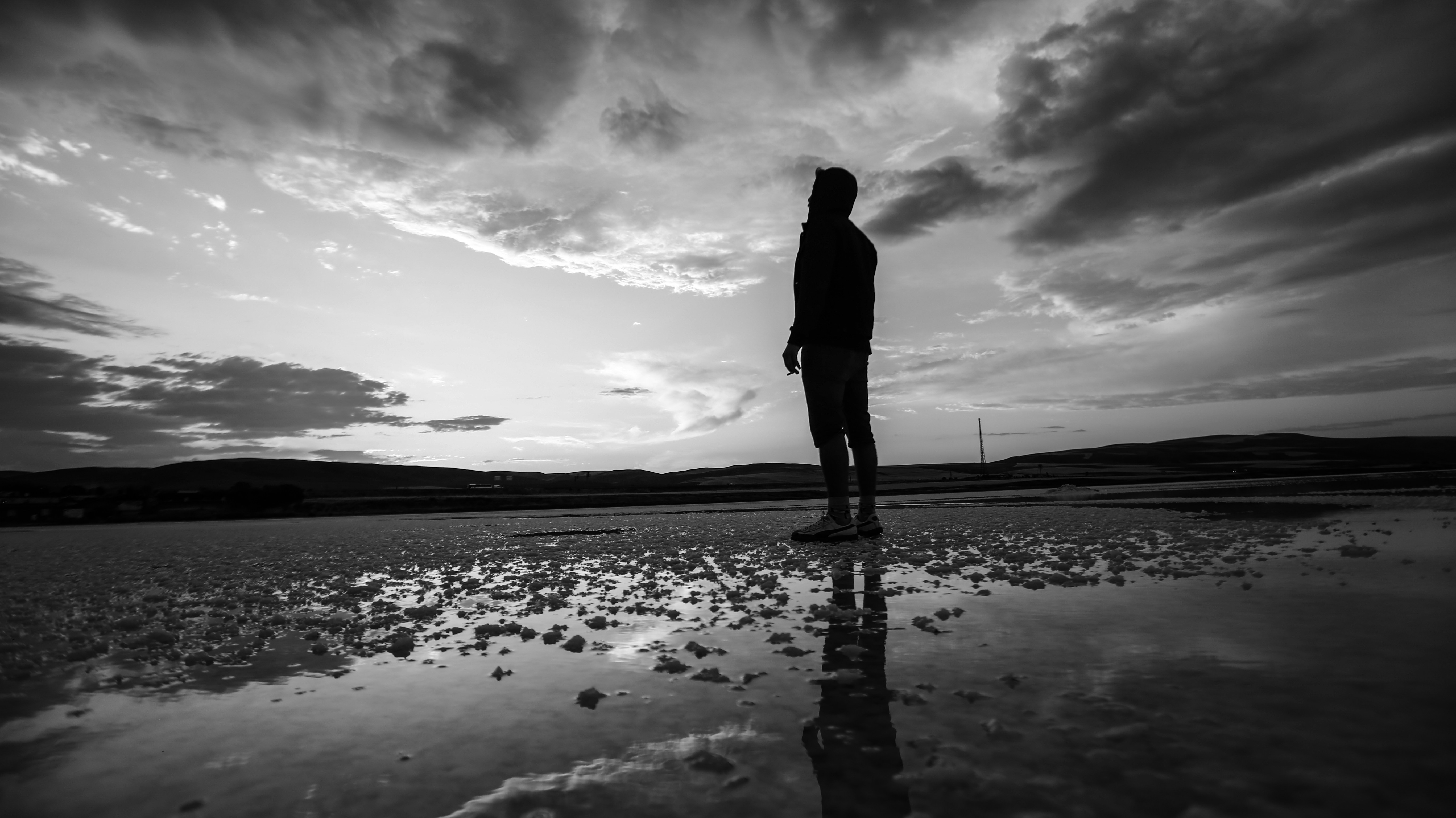 A person standing on a beach at sunset