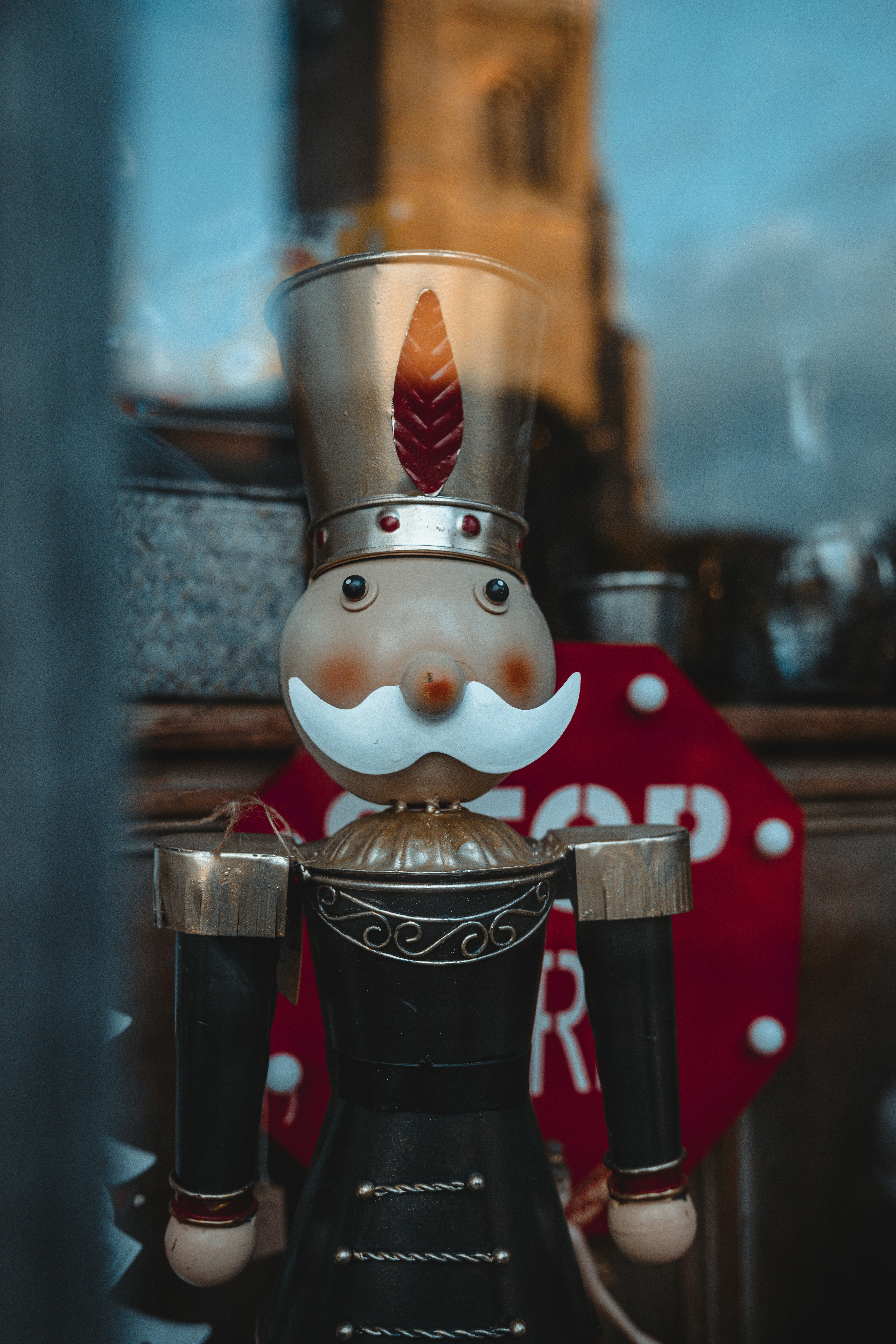A nutcracker is standing in front of a window