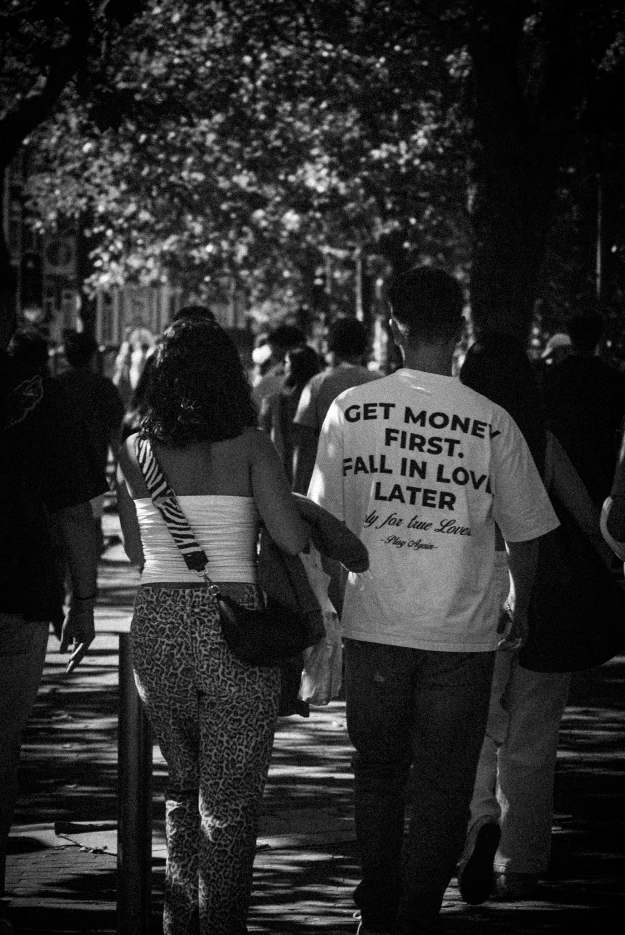 A group of people walking down a sidewalk