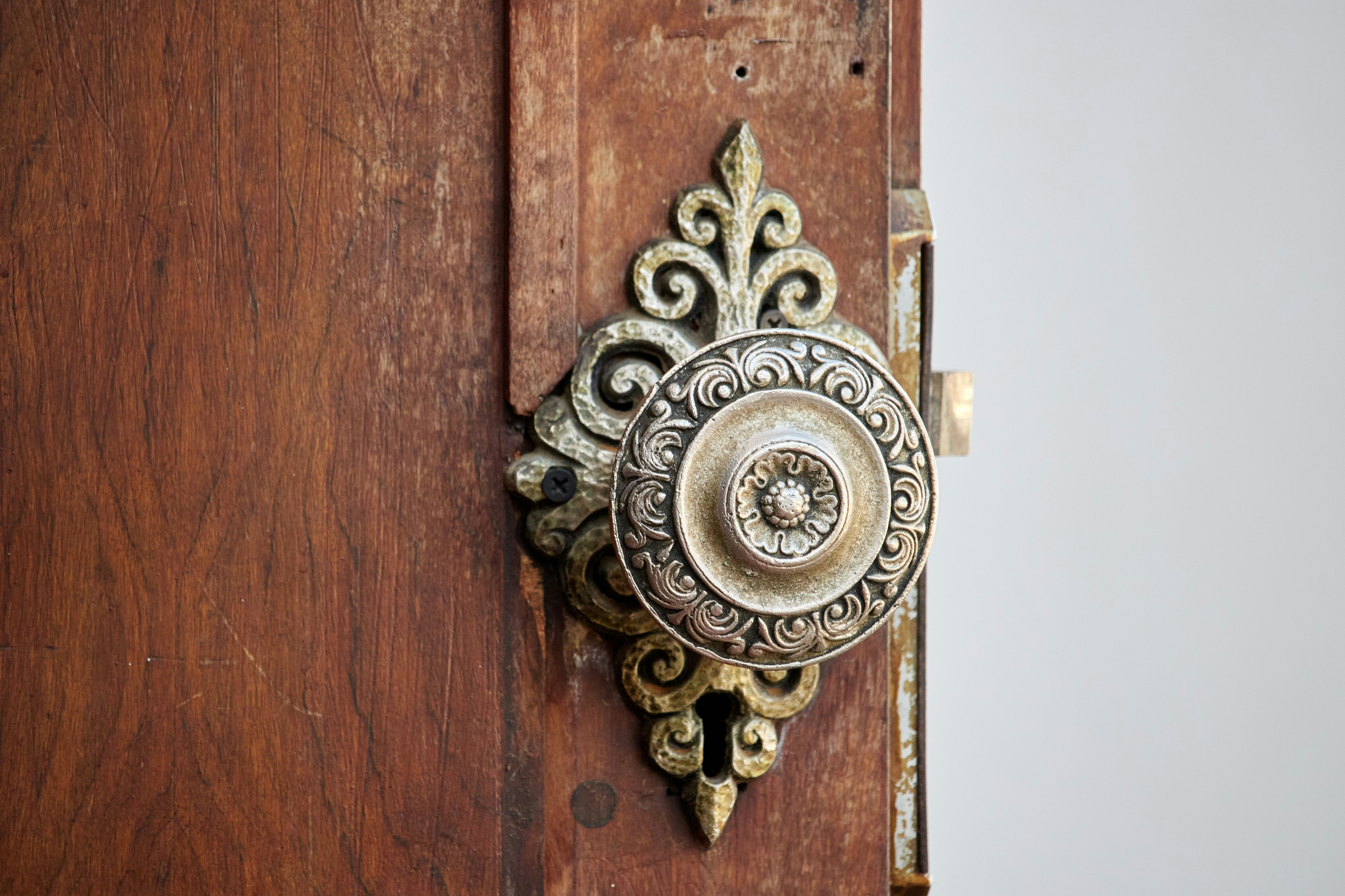 A close up of a door handle on a wooden door