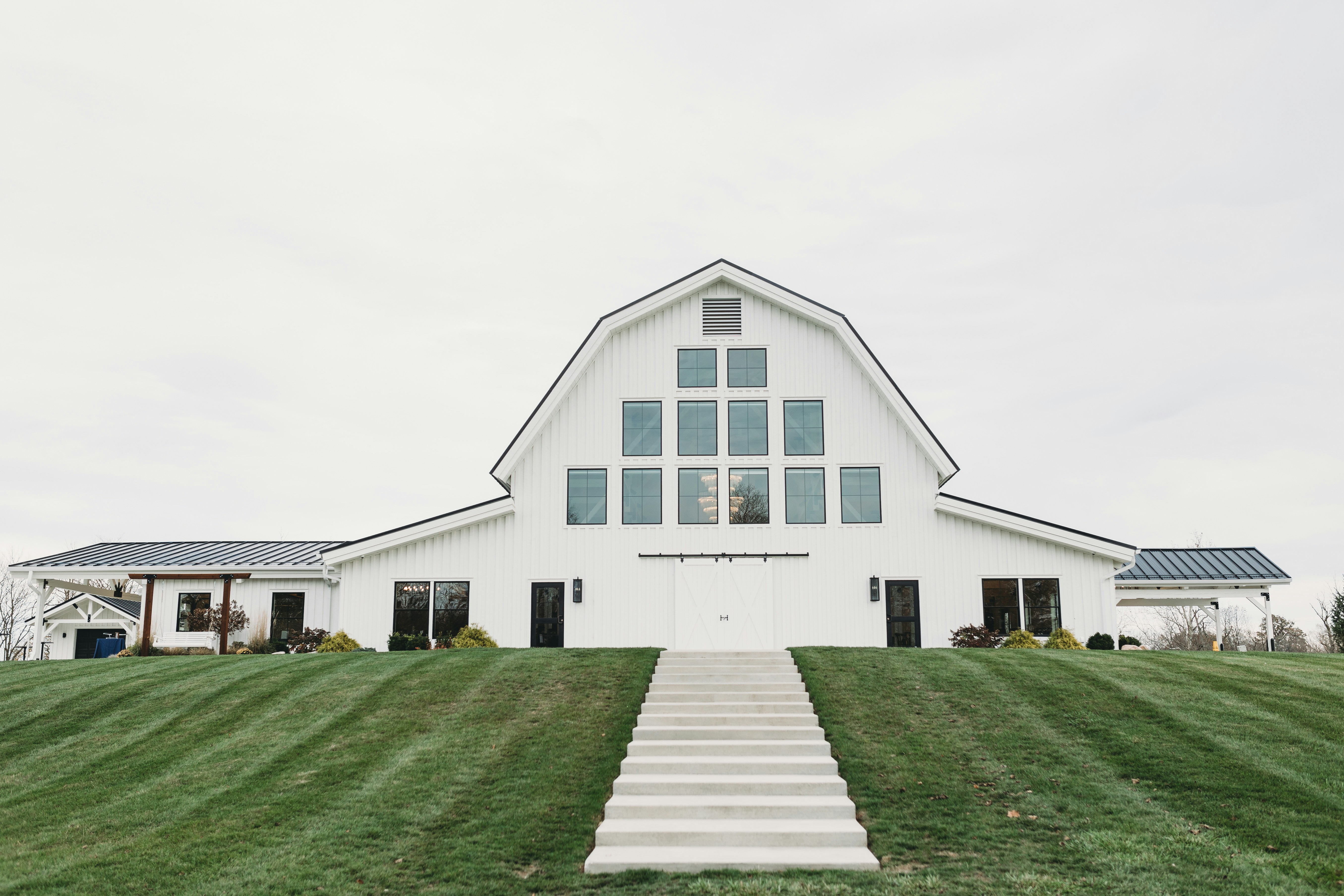 A white barn with stairs leading up to it