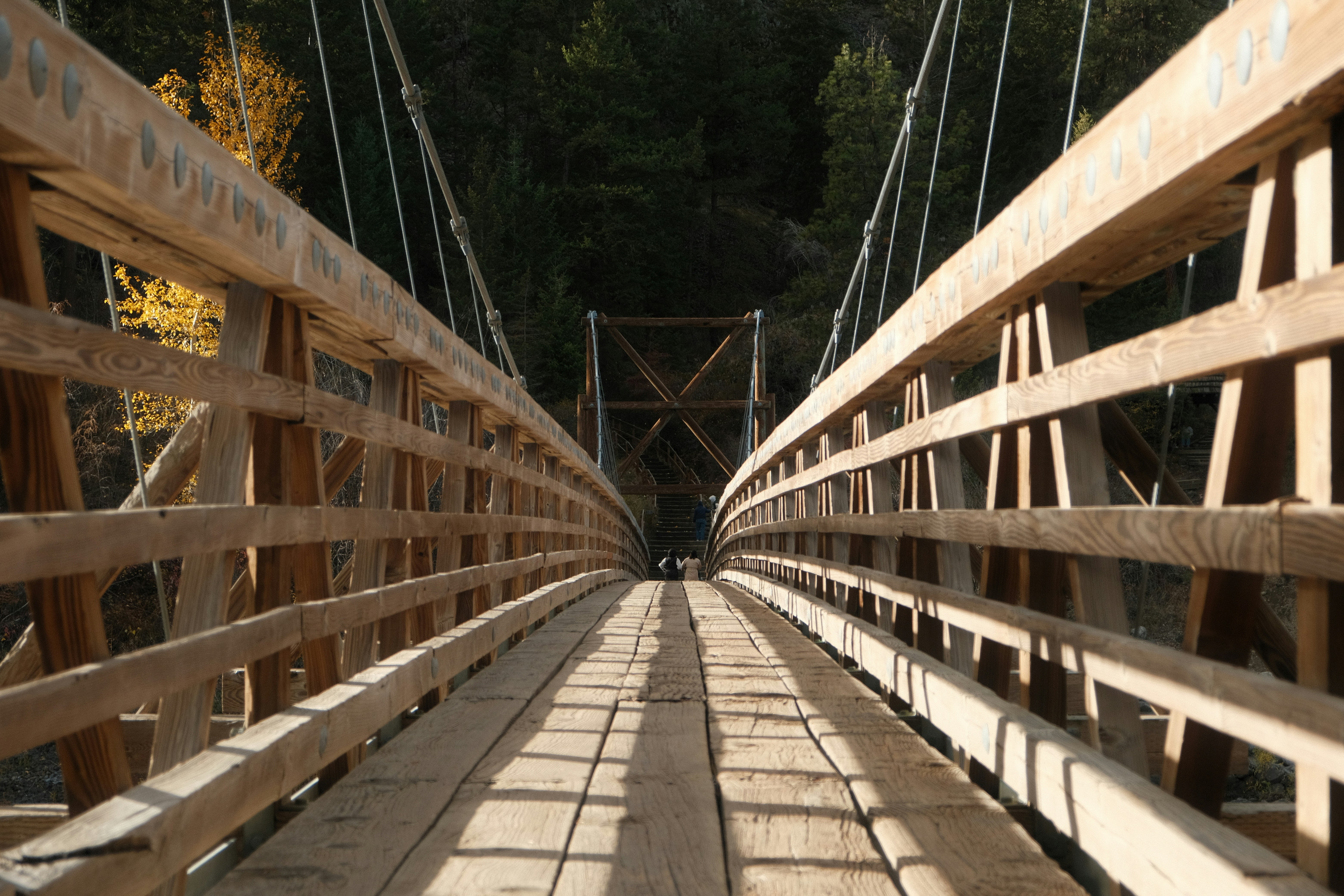A wooden bridge with a person walking across it
