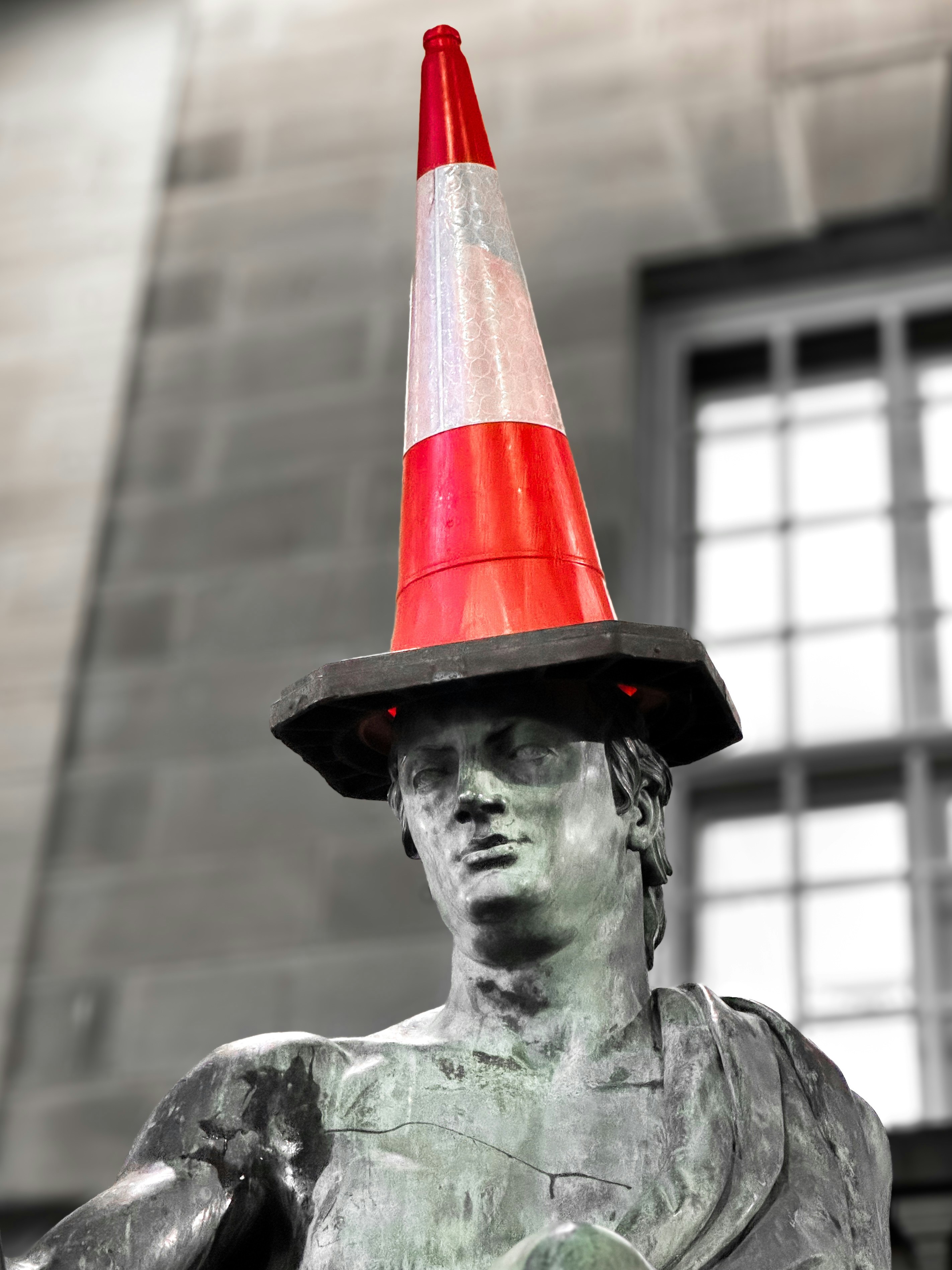 A statue with a traffic cone on top of it