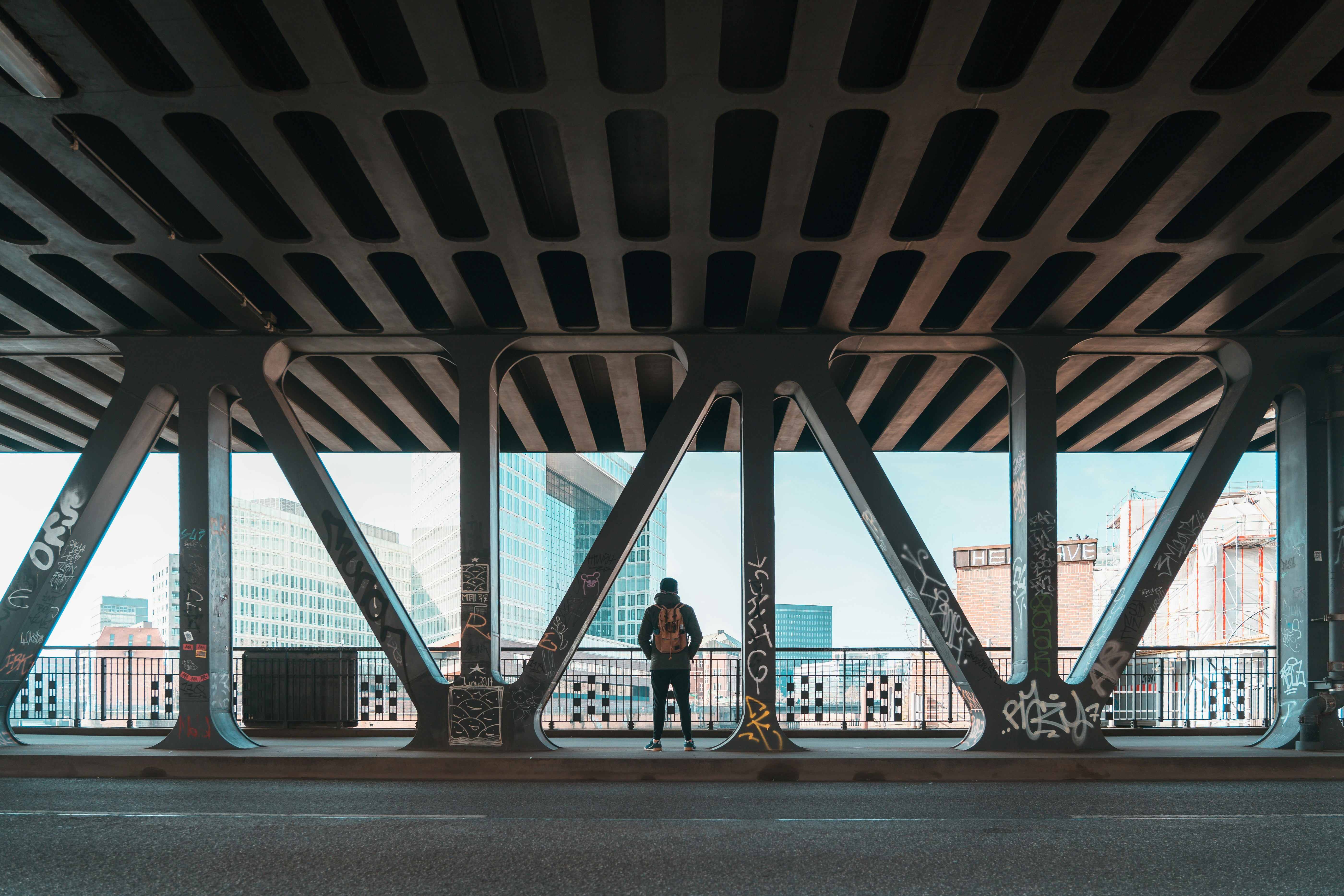 A person standing on a bridge looking out at the city