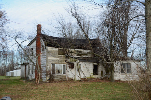 An old run down house in the middle of a field