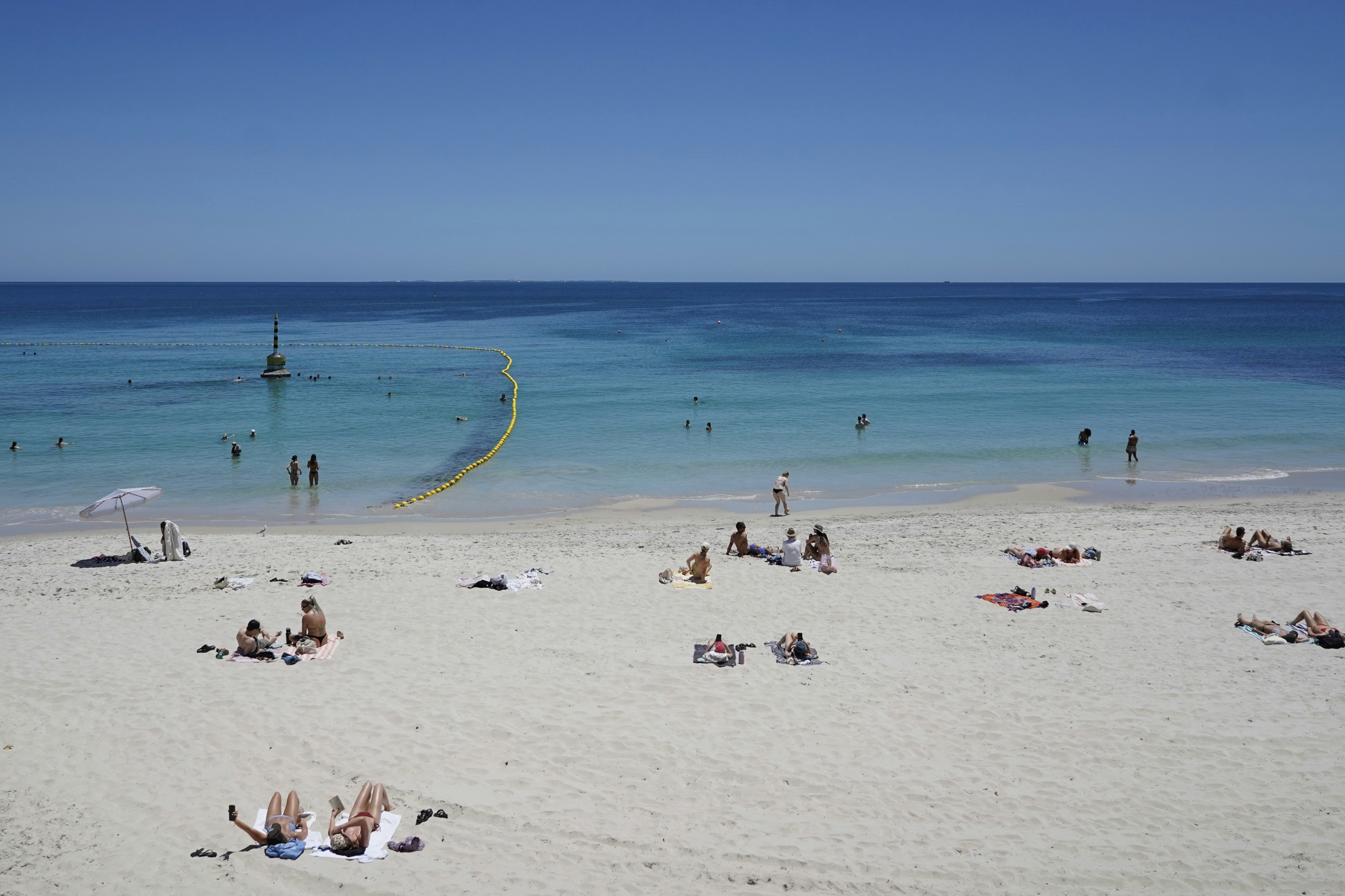 A group of people laying on top of a sandy beach