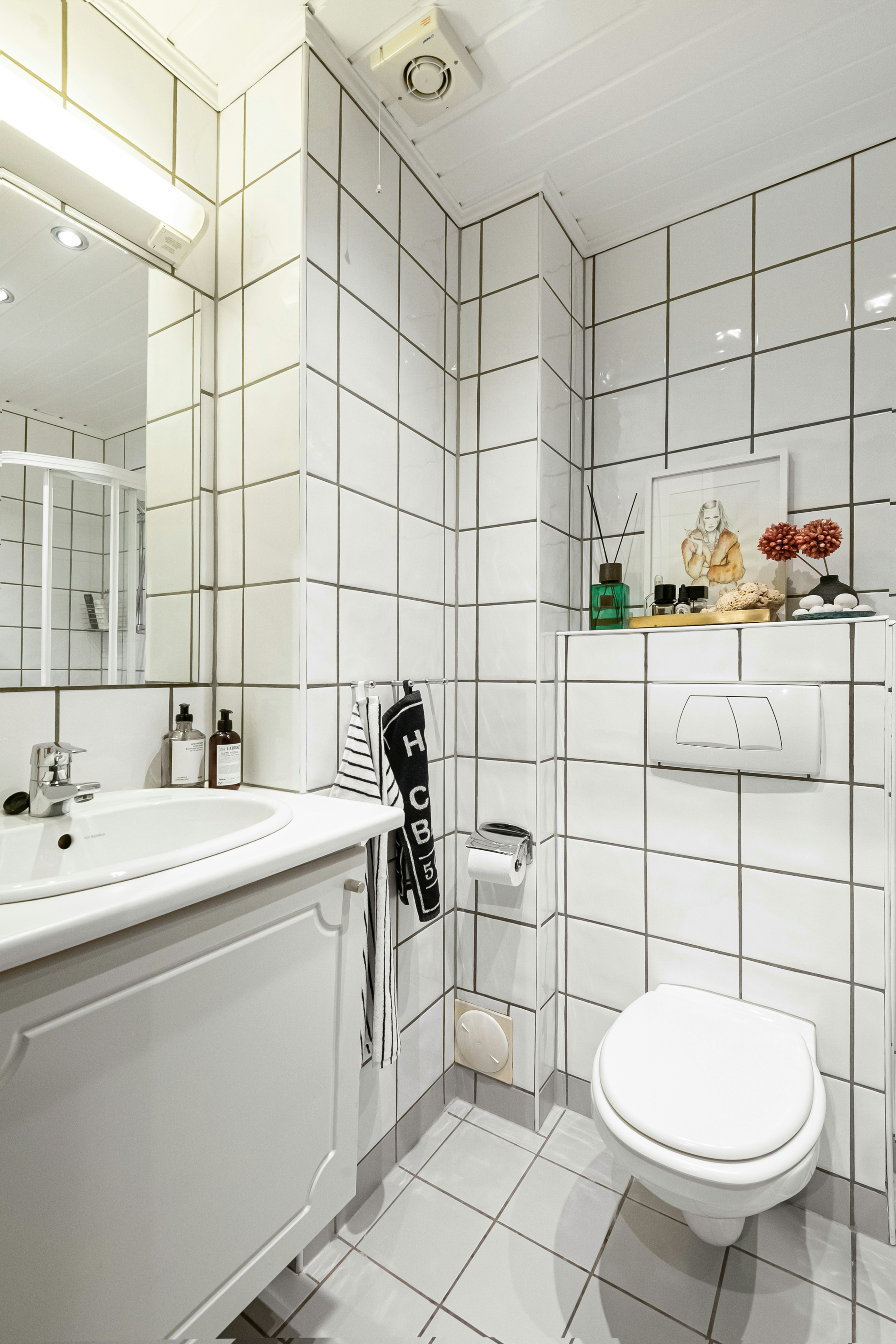 Ein Badezimmer mit WC, Waschbecken und Spiegel