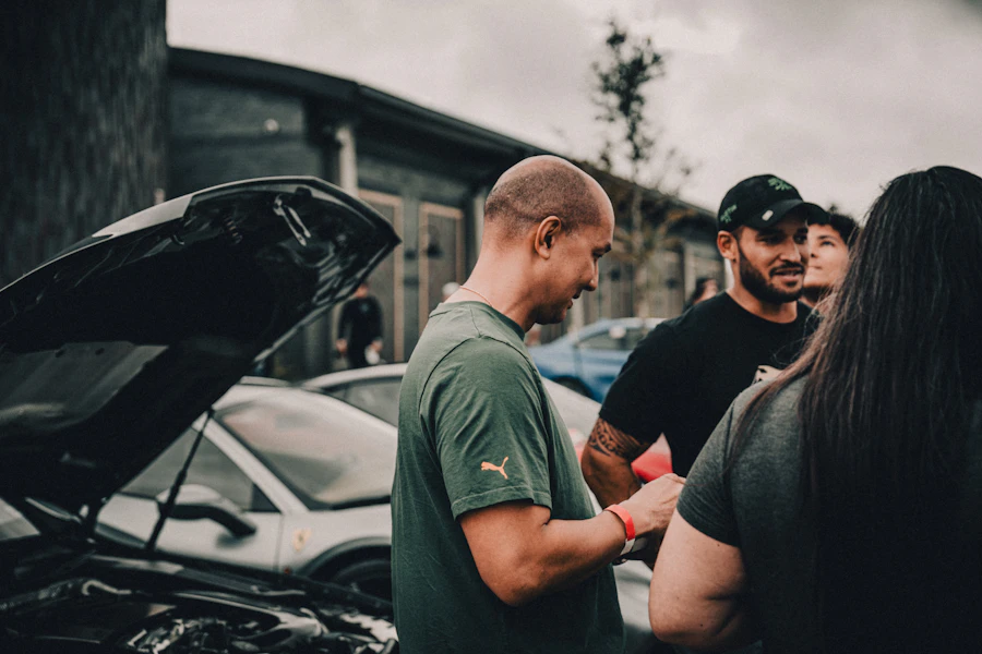 Group of people gathered around a parked car in a lot &mdash; every car in a parking lot near you is a potential customer waiting for your flyer