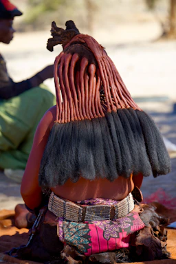 A woman sitting on the ground with a hat on her head