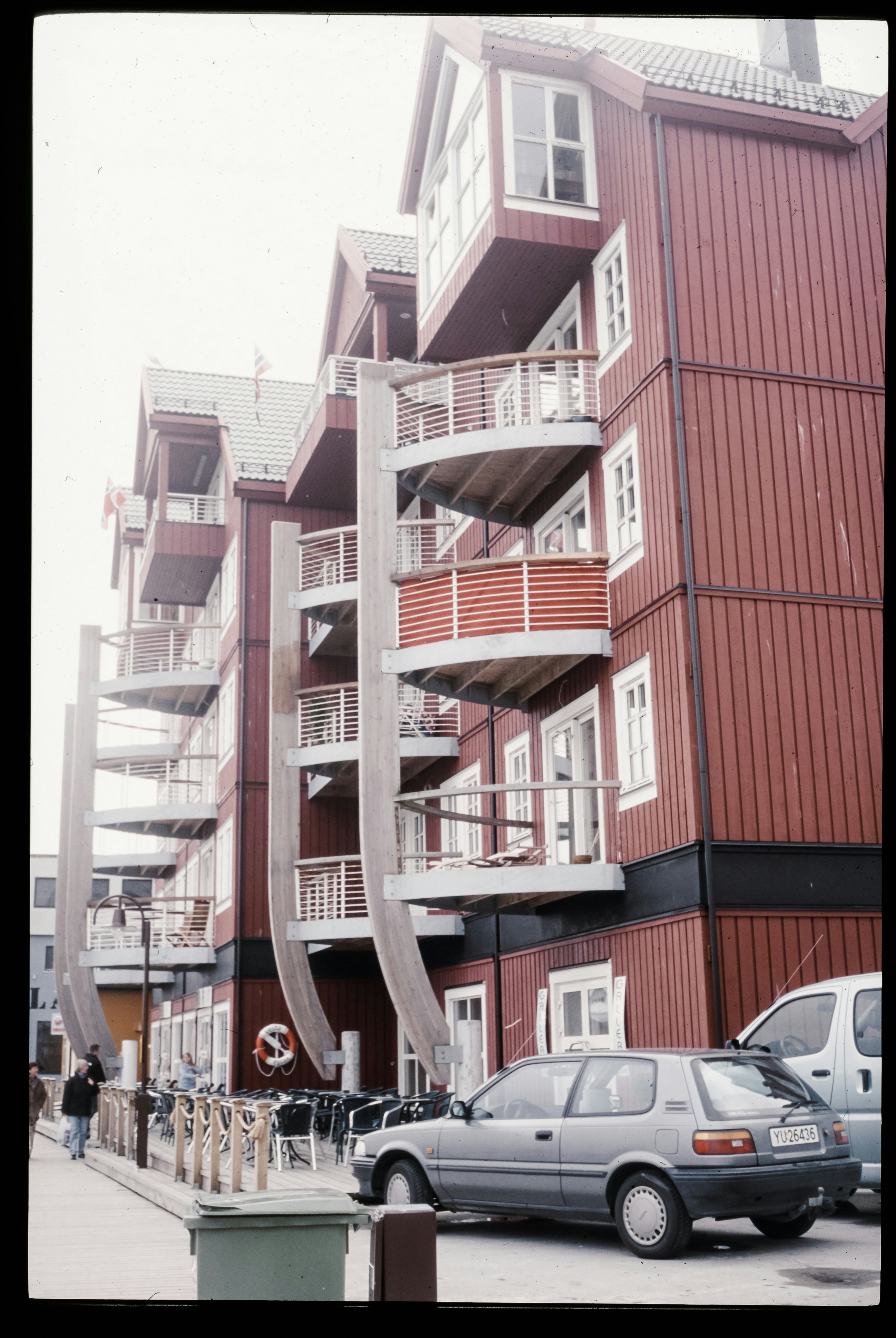 A car parked in front of a tall red building