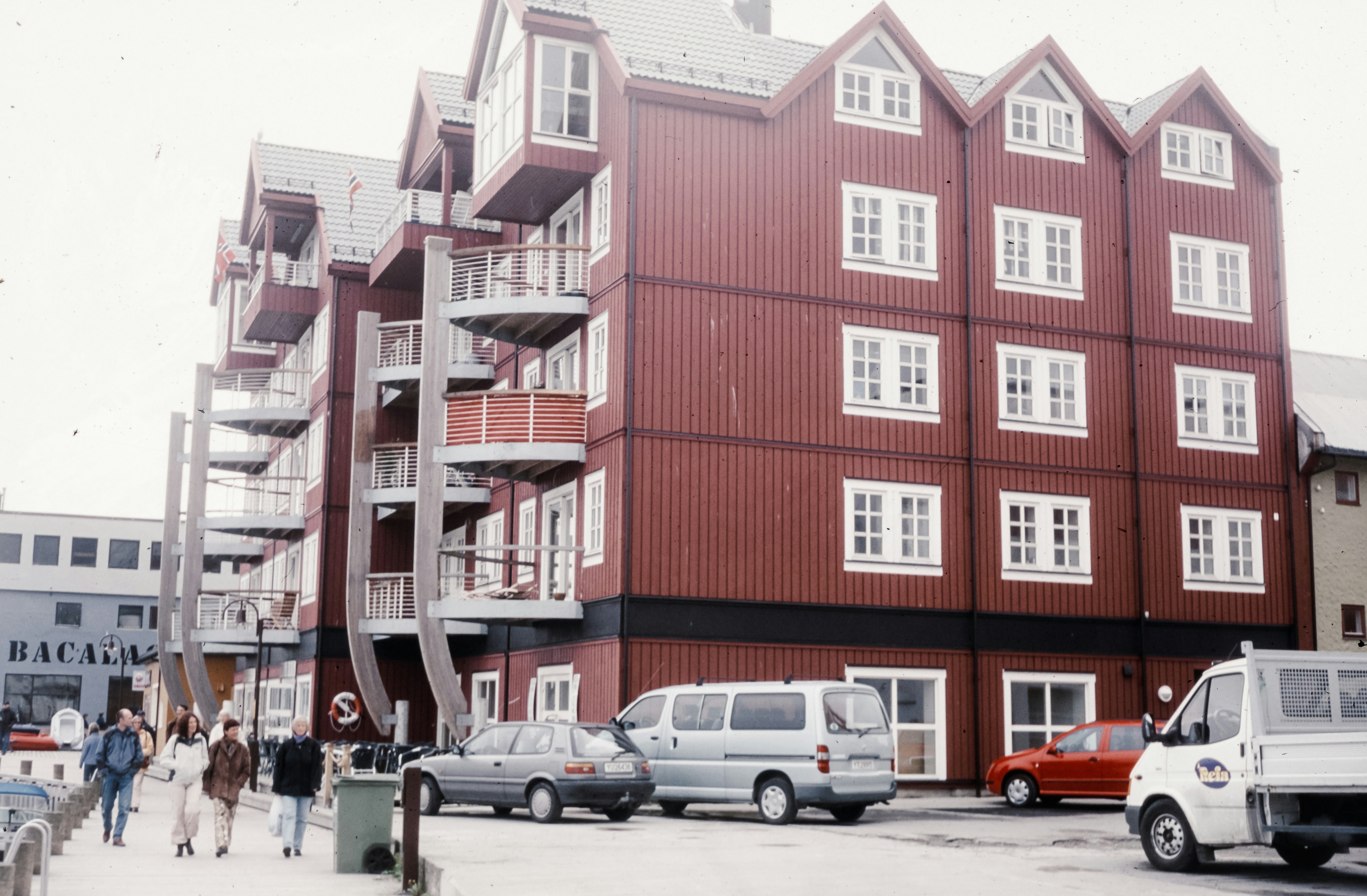 A group of people standing outside of a red building
