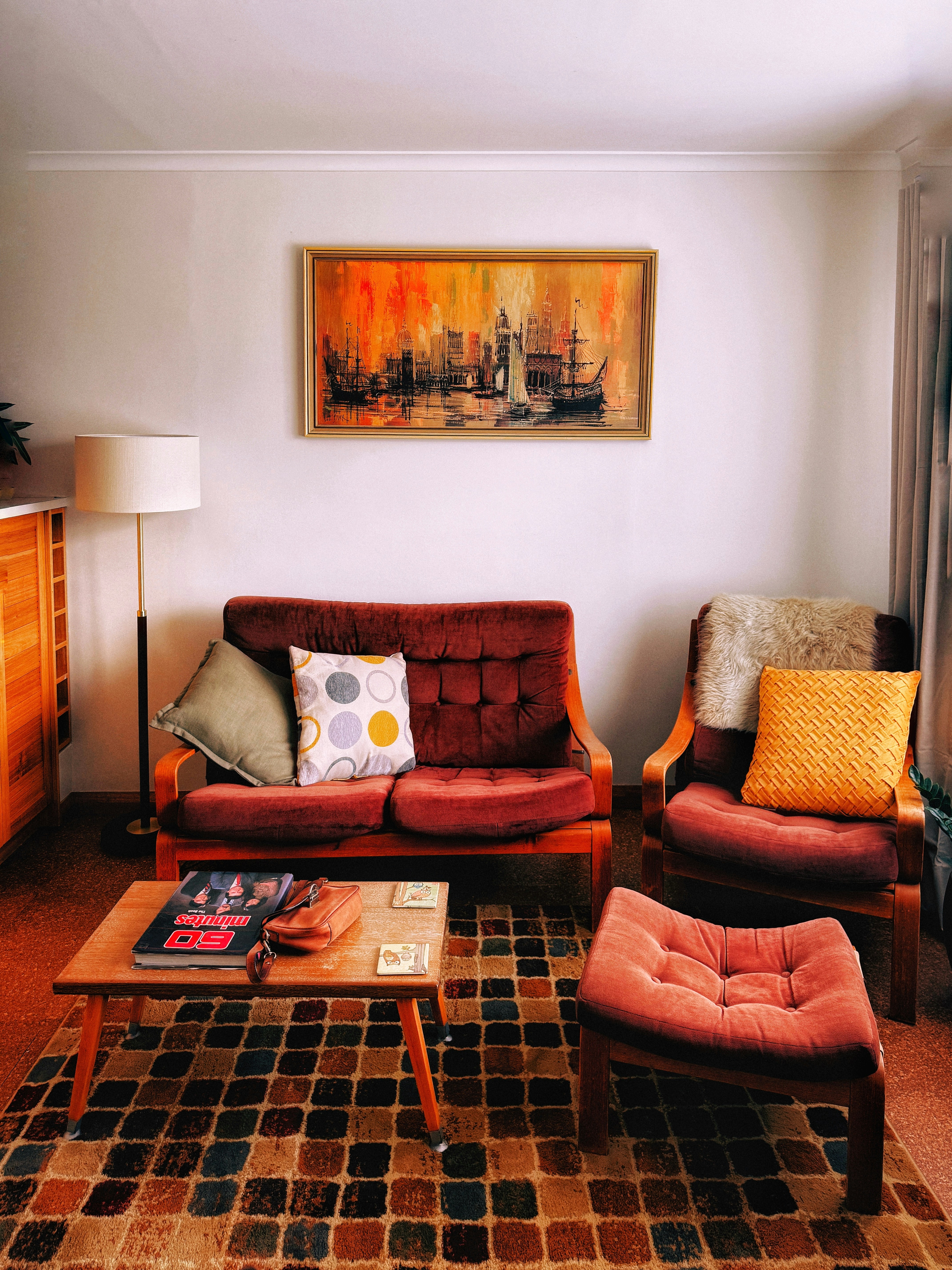 A living room filled with furniture and a painting on the wall