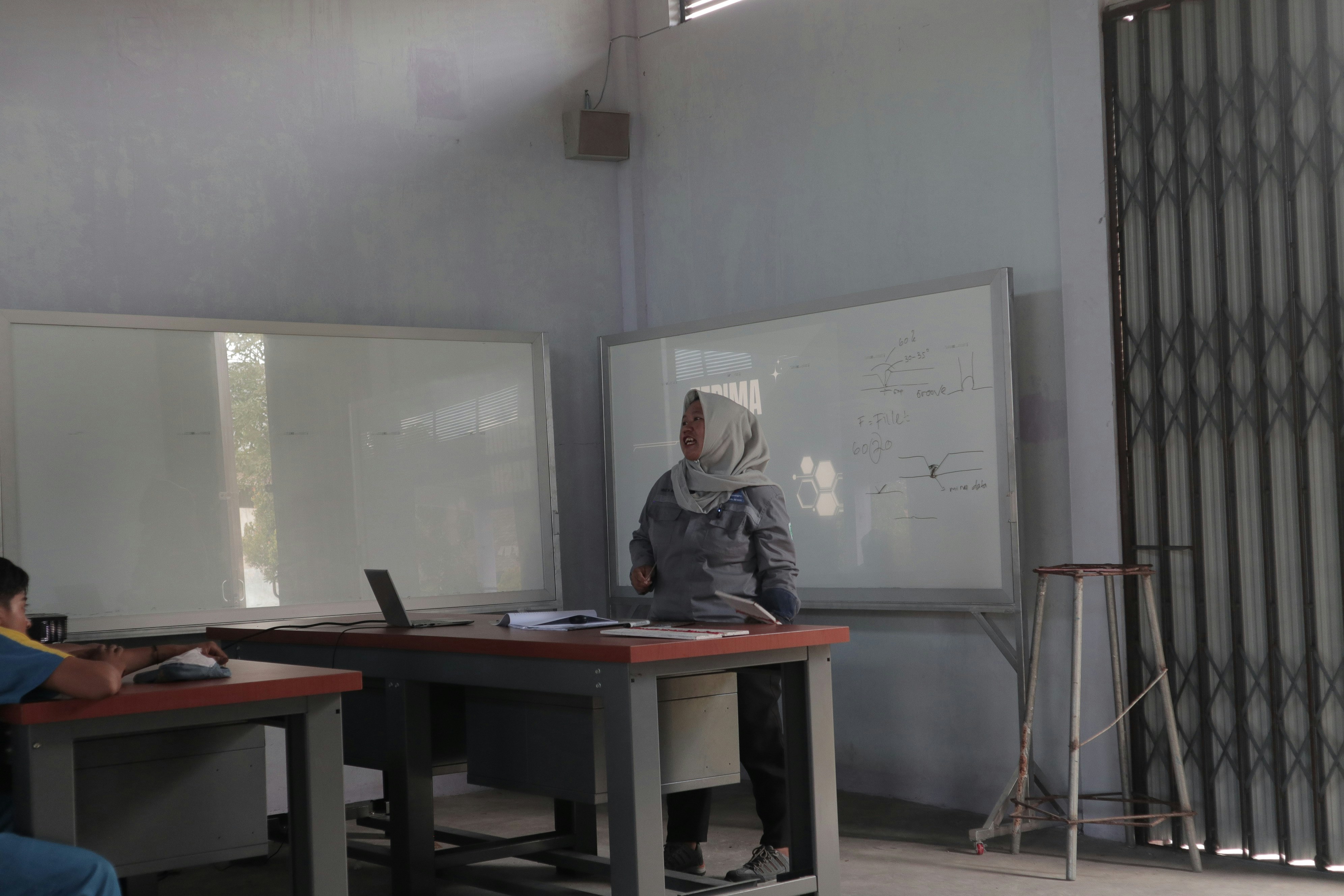Professional Arab woman in modern hijab and blazer standing confidently in front of whiteboard with mathematical equations