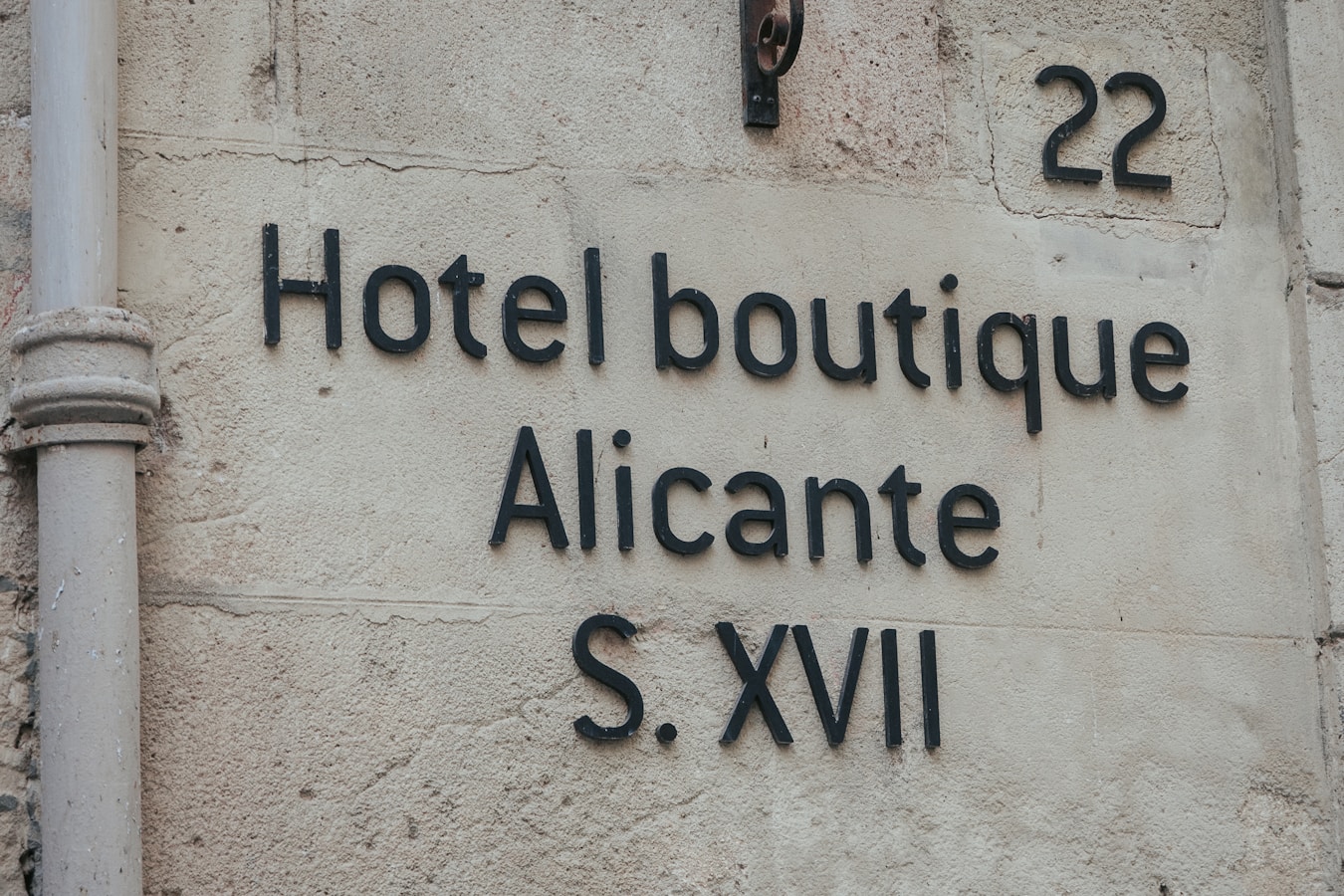 A sign on the side of a building that says hotel boutique alicante s