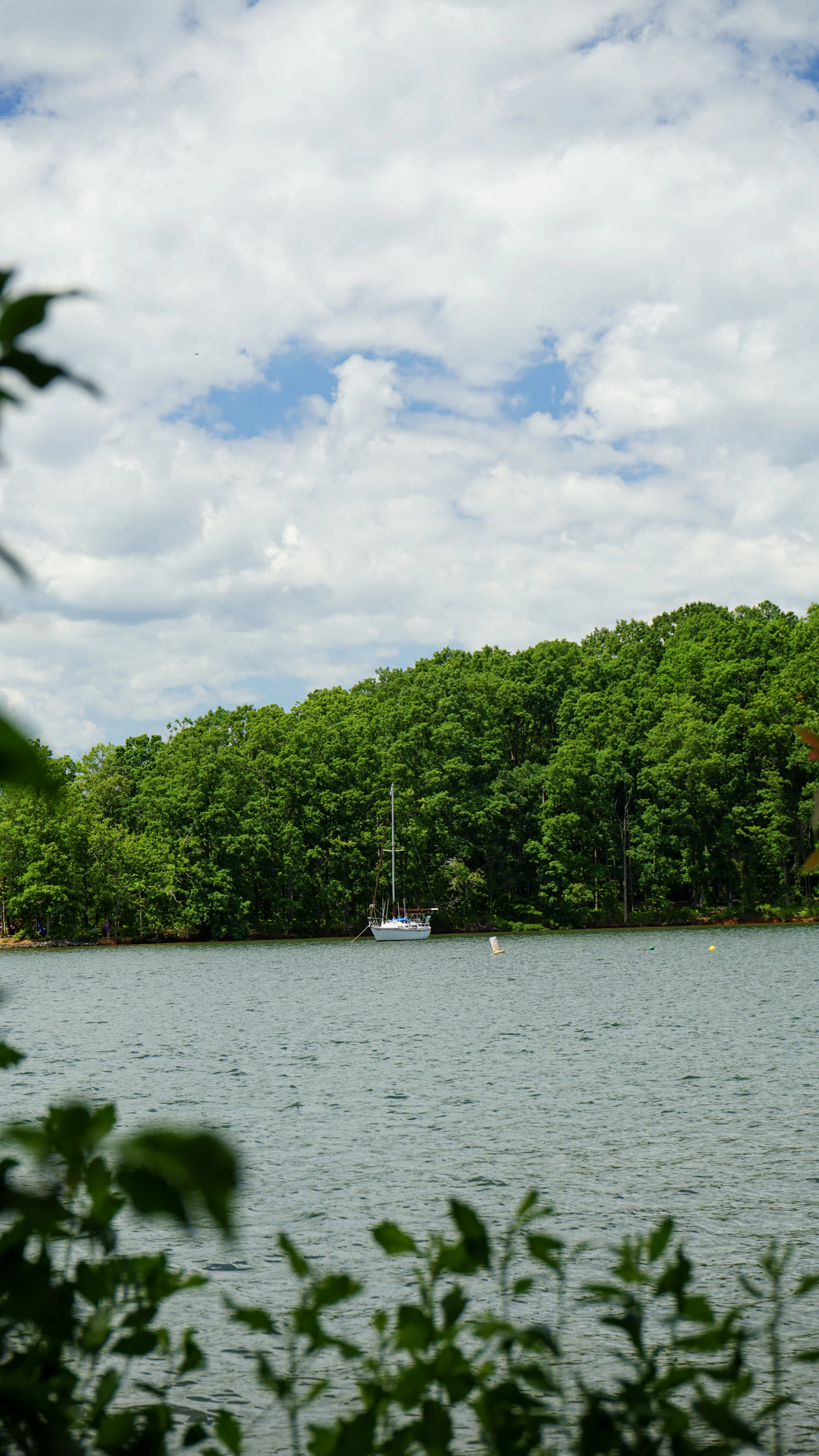 A lake shoreline under scattered clouds.